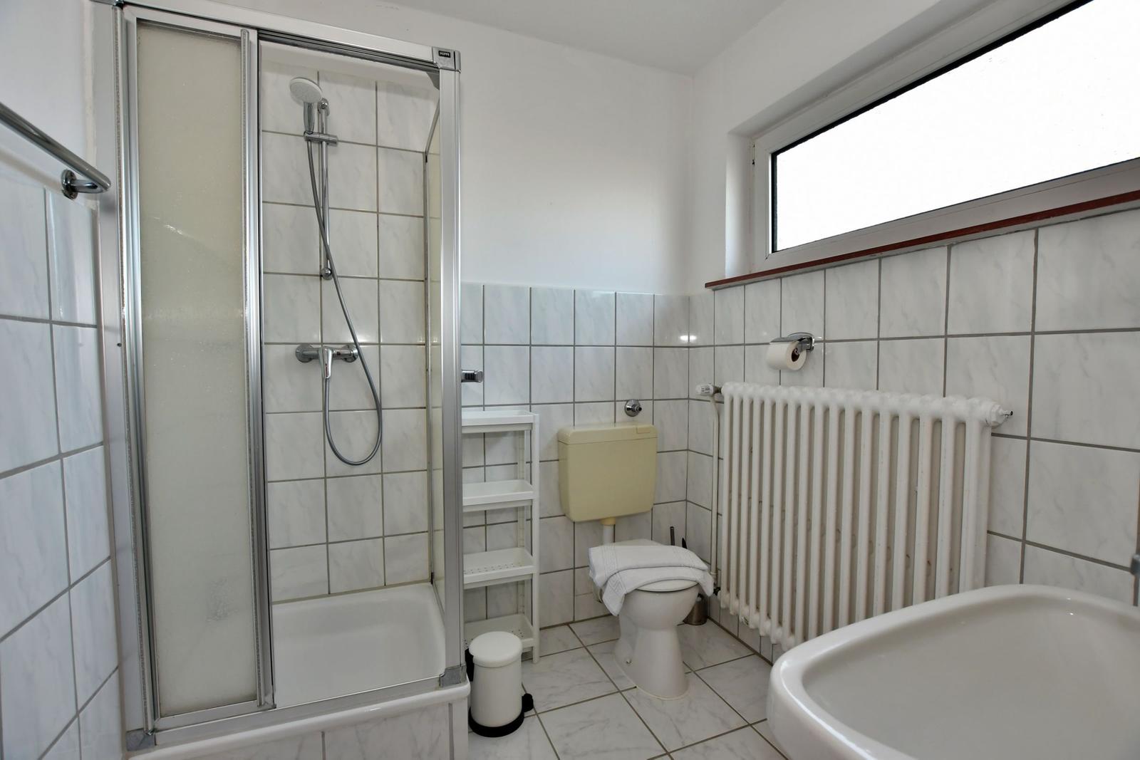 Badezimmer mit Dusche, Toilette und Waschbecken