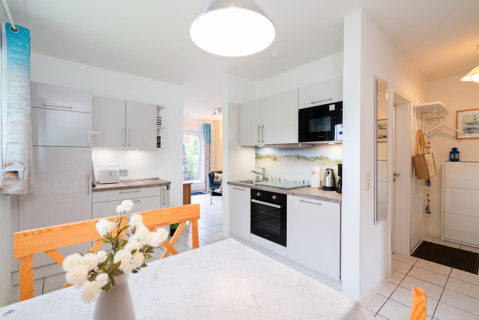 Kitchen with dining area, white cabinets, and appliances.