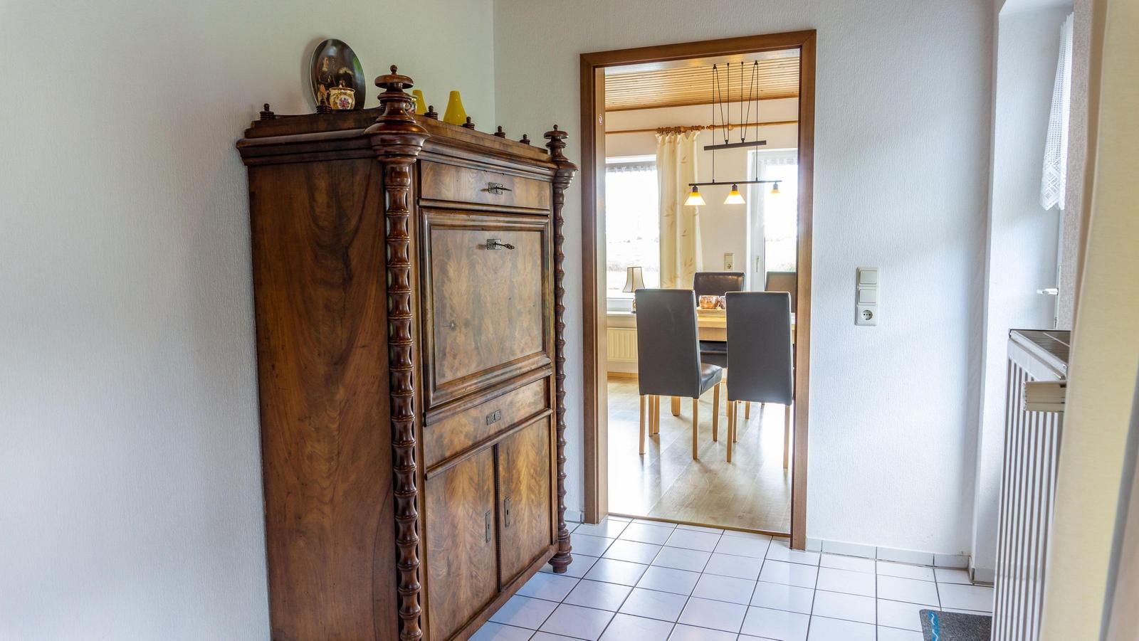 Haus mit Eingangsbereich, antikem Schrank und Blick in das Esszimmer.