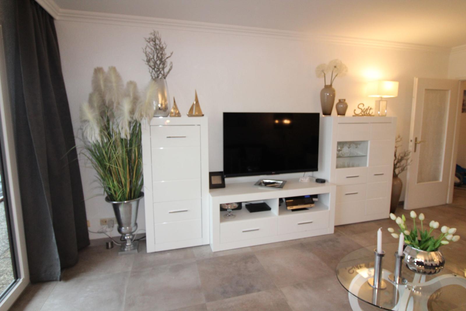 Living room with TV, white cabinets, and plants.
