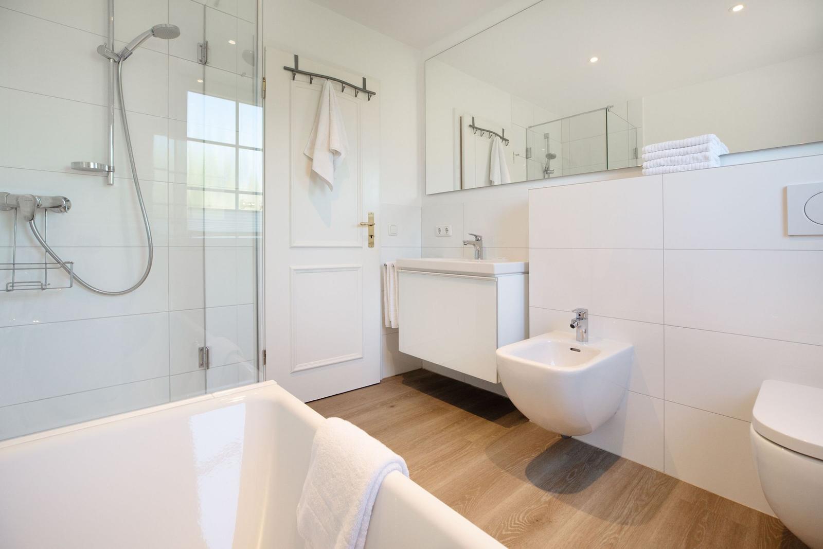 Badezimmer mit Badewanne, Dusche, Waschbecken und Toilette.