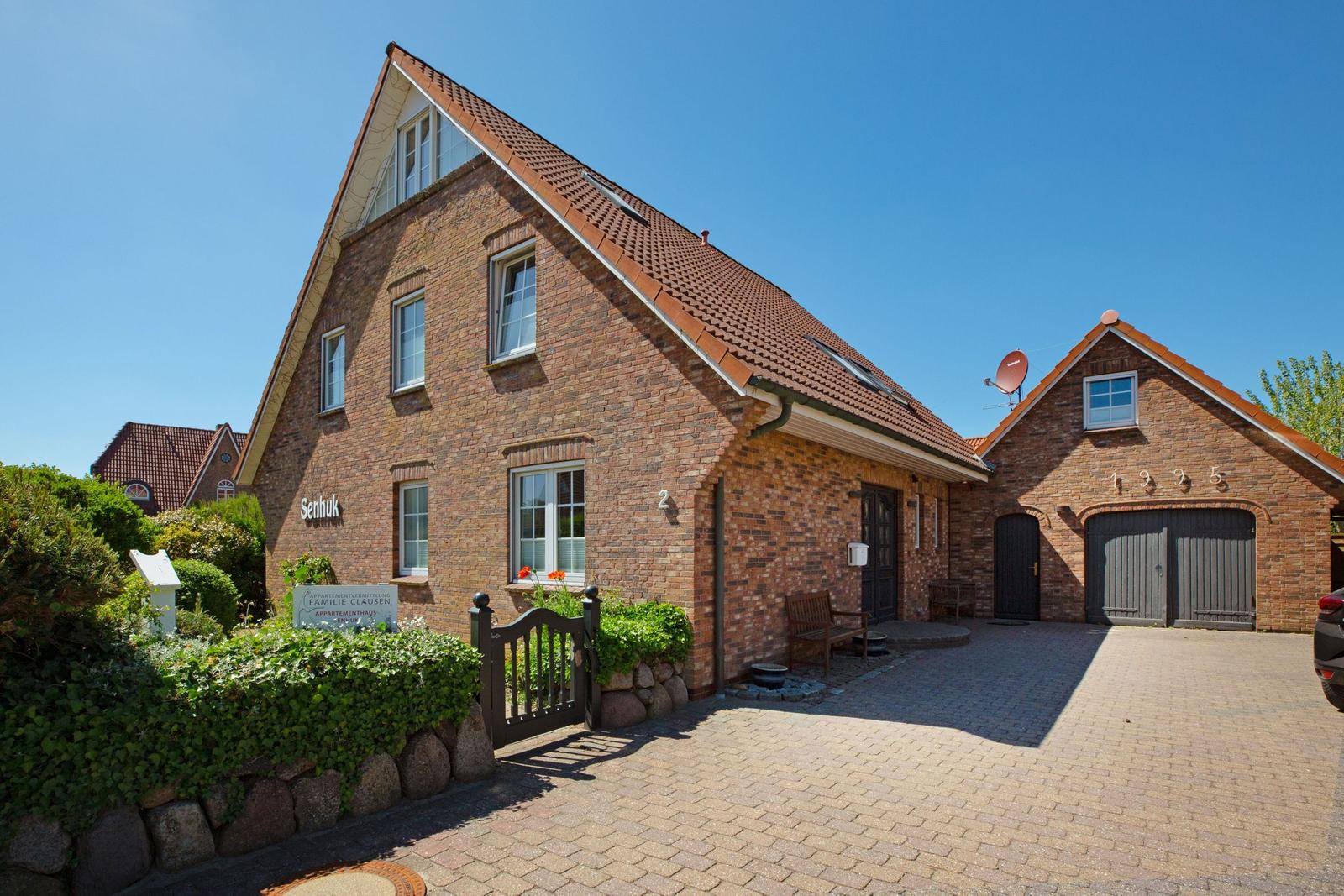 Rotes Ziegelhaus mit Garagenbereich und gepflastertem Hof