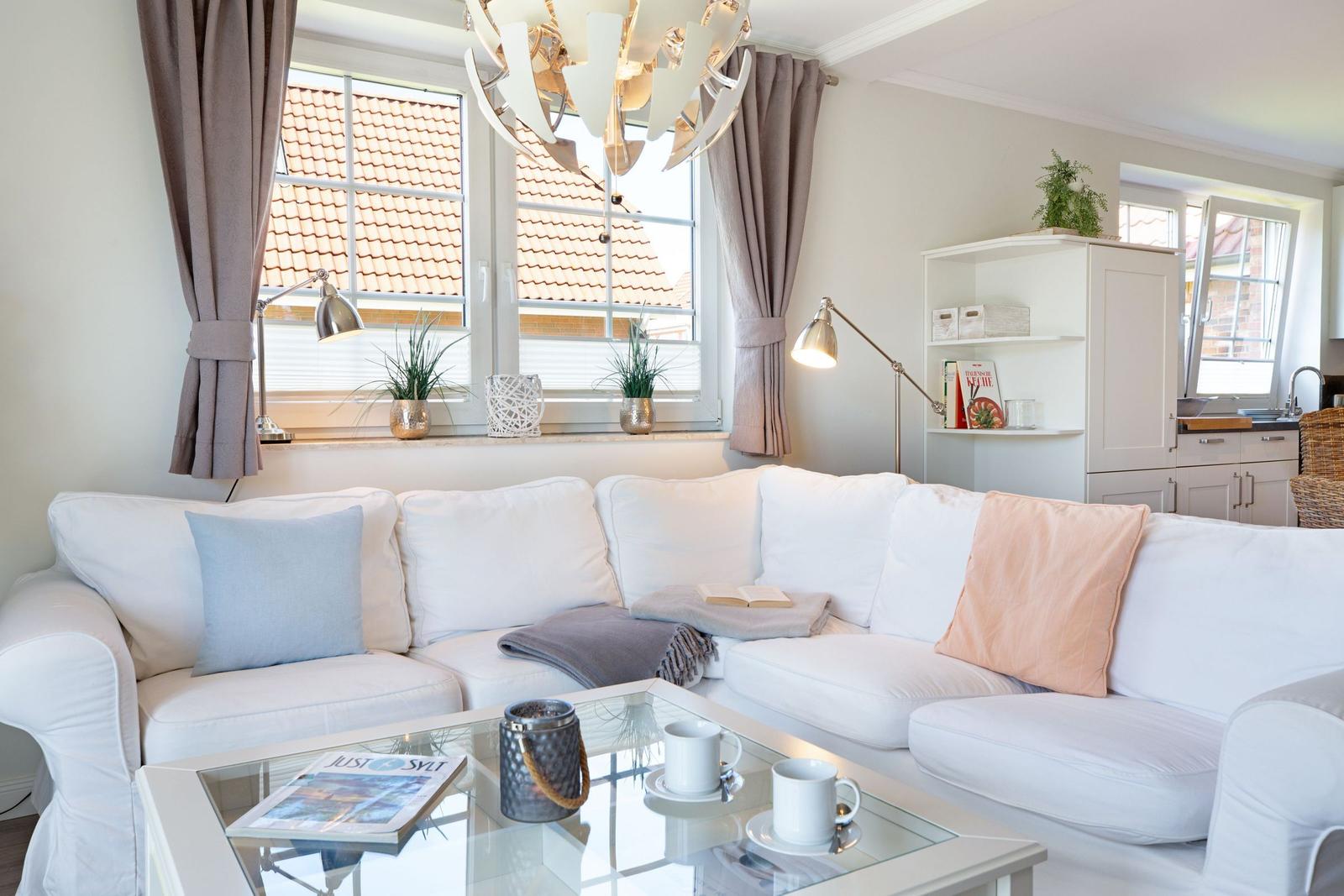 Wohnzimmer mit weißem Sofa, Glas-Tisch und Blick auf Dach