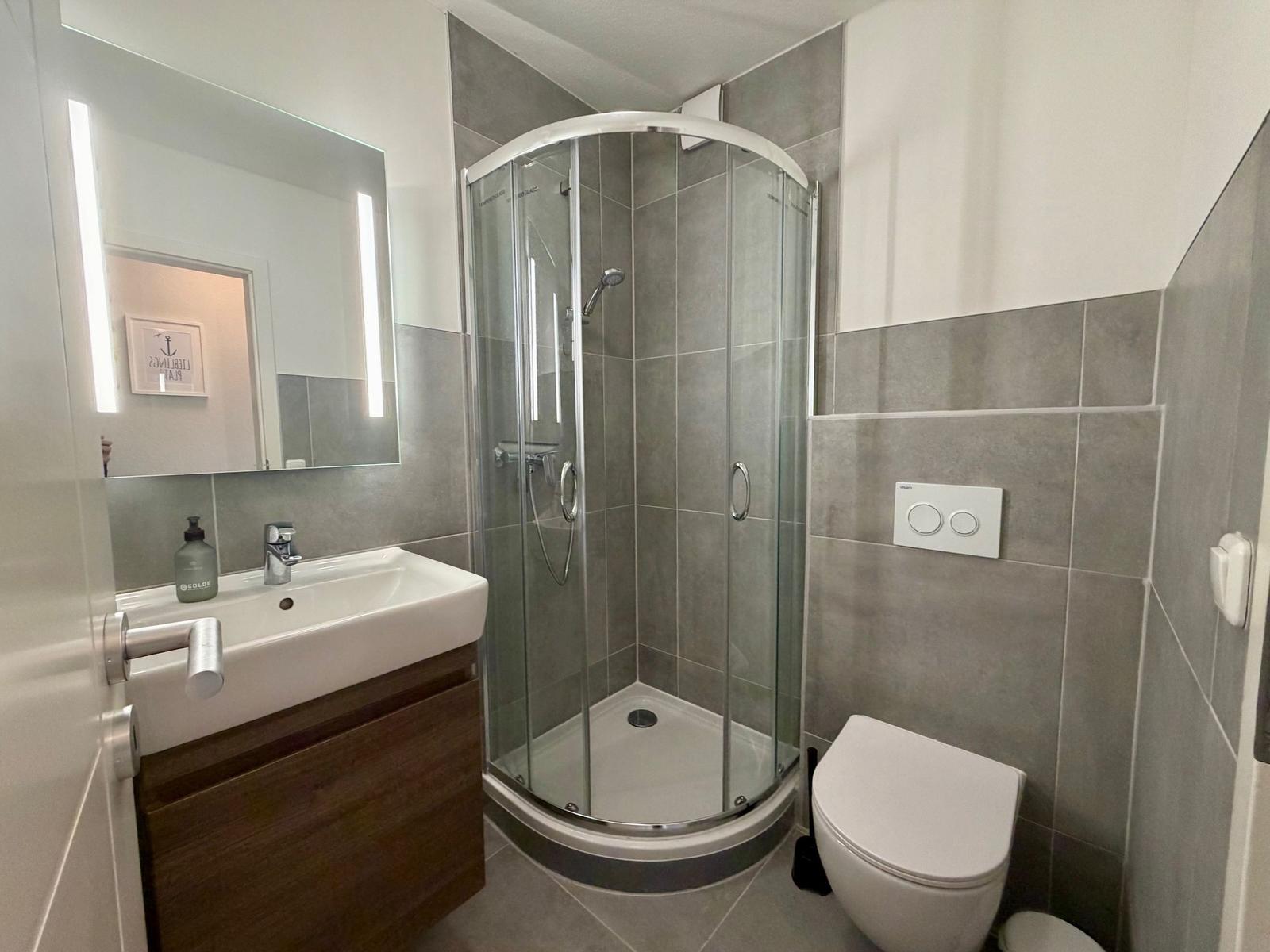 Bathroom with shower, sink, and toilet.