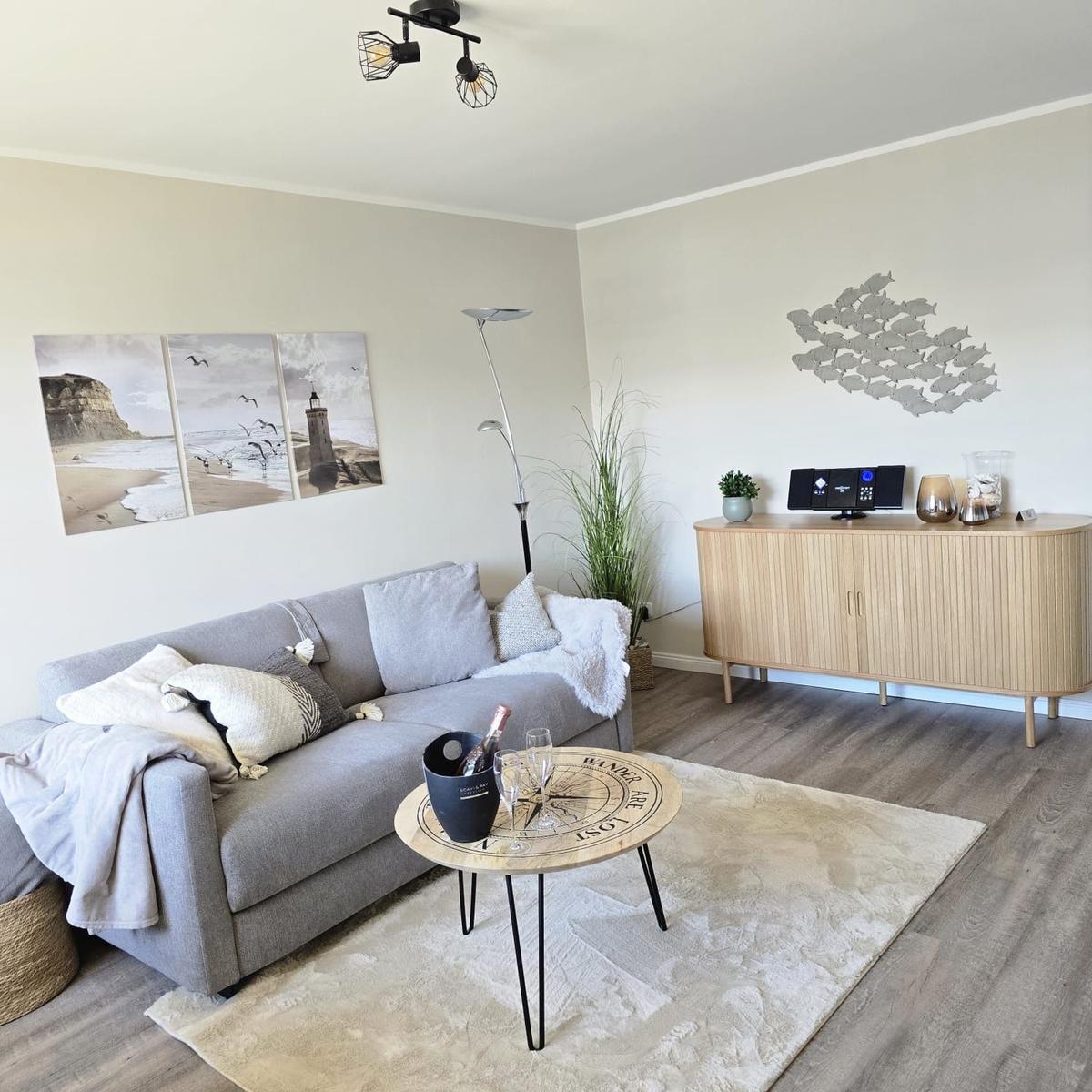 Living room with gray sofa, round table, and wooden cabinet.