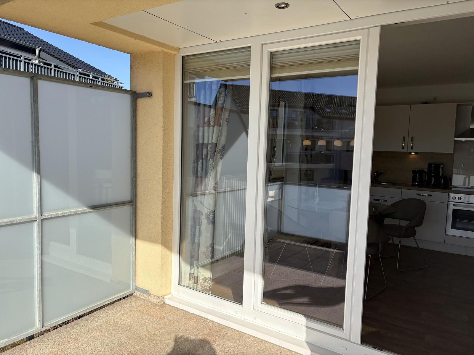 Terrasse mit Schiebetüren zu Küche und Wohnbereich