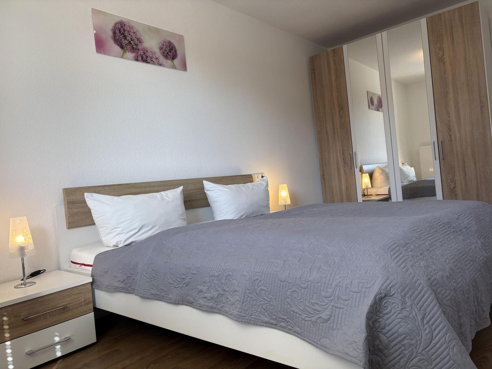 Schlafzimmer mit Doppelbett, Nachttisch und Kleiderschrank.