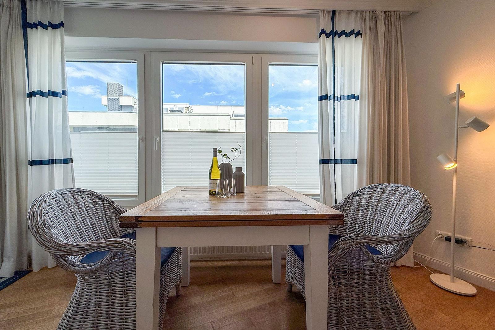 Esstisch mit zwei Stühlen vor Fenster mit Blick auf Gebäude