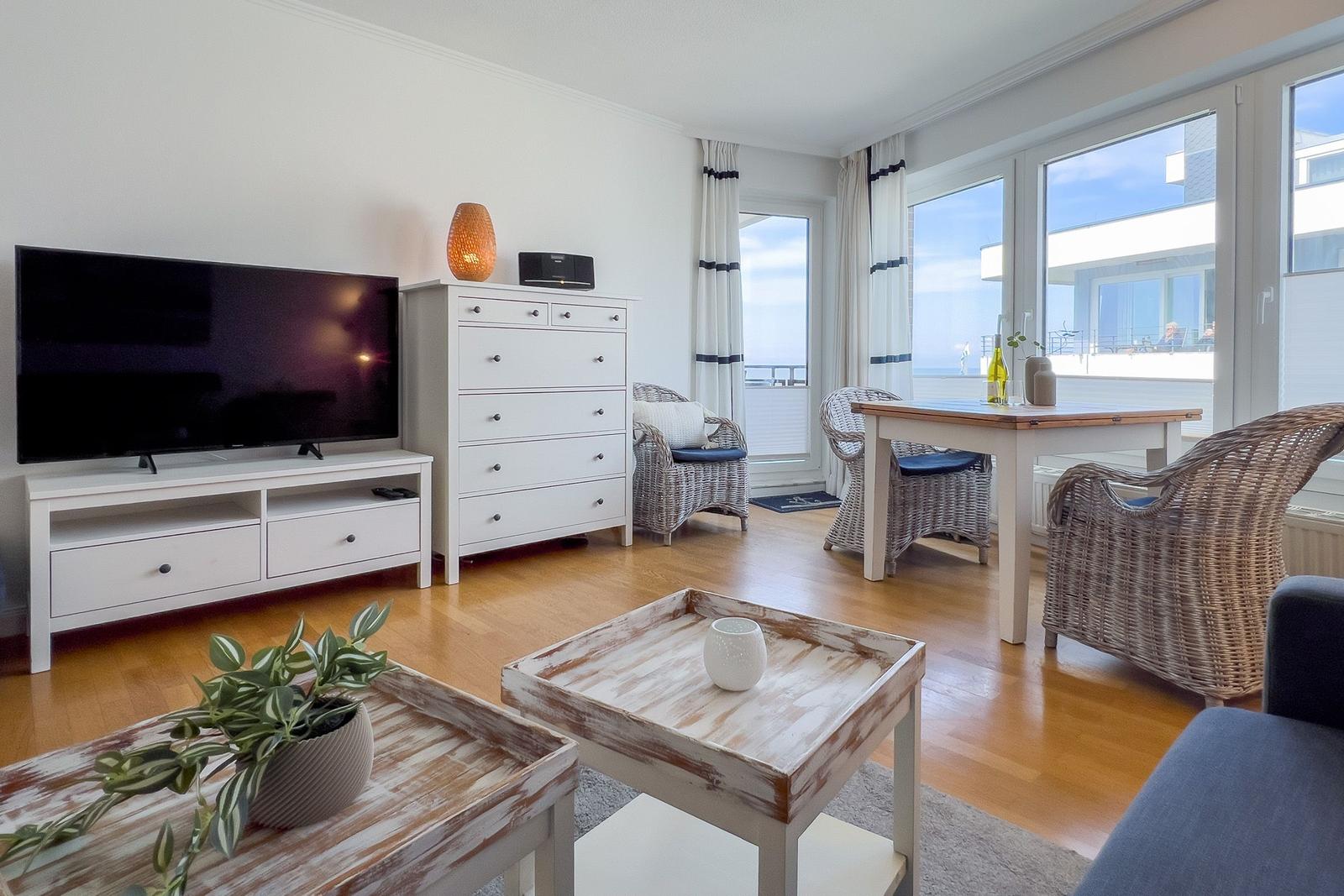 Wohnzimmer mit TV, Schrank, Esstisch und Blick auf Balkon