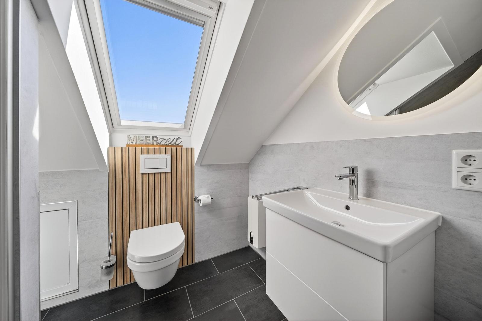Badezimmer mit Dachfenster, Toilette und Waschbecken