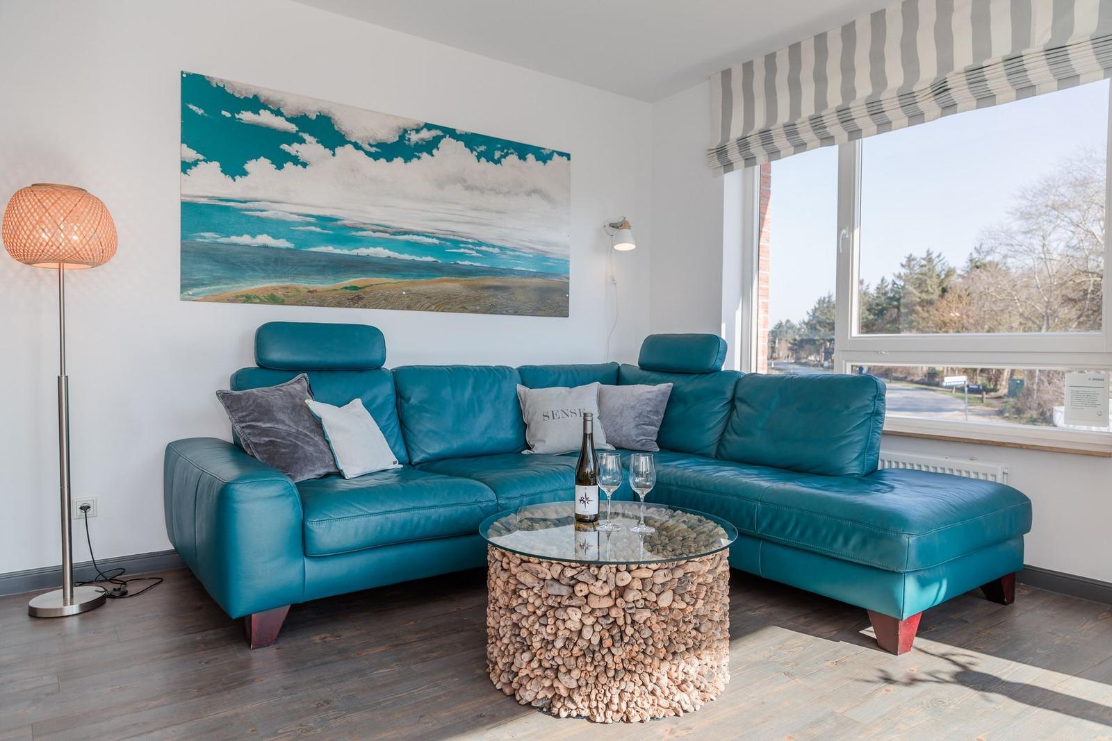 Living room with blue sofa, round table, and wall art.