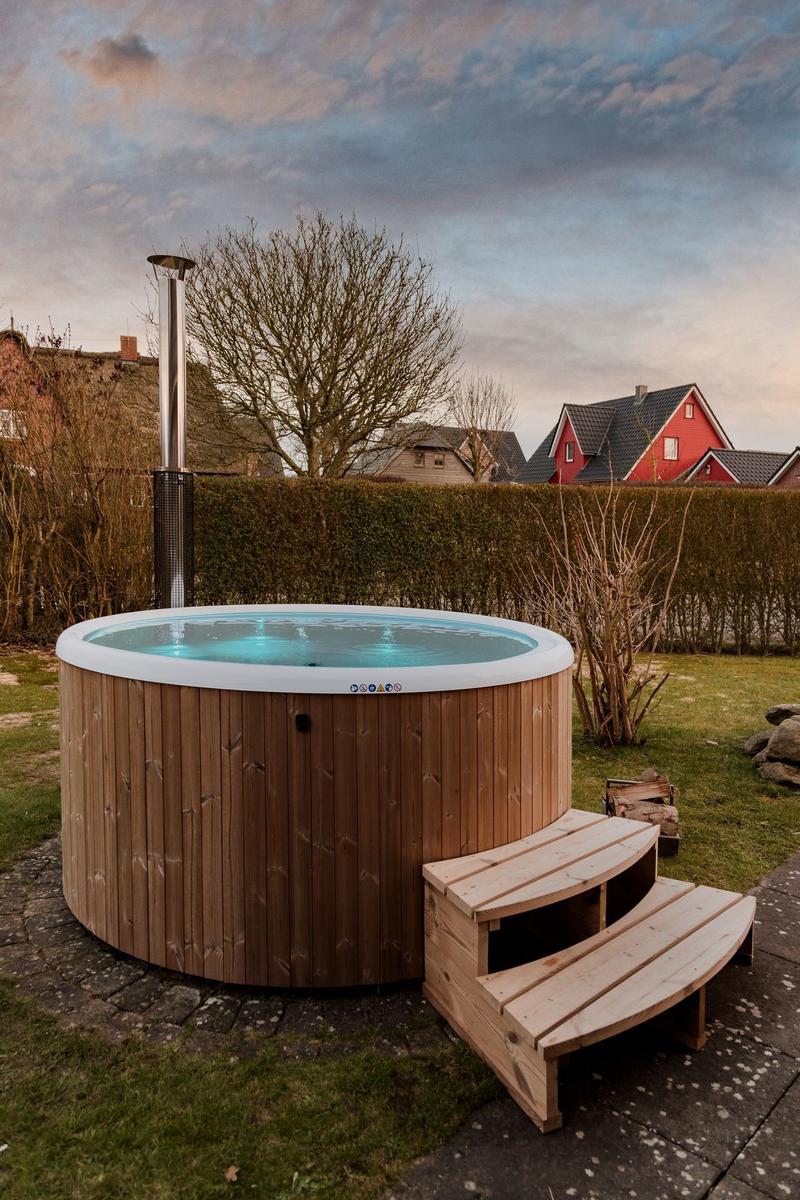 Hochwertiger Whirlpool mit Holzrahmen und integriertem Ofen im Garten