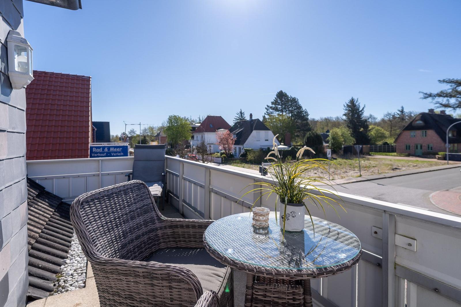 Terrasse mit Sitzgruppe und Blick auf Wohngebiet.