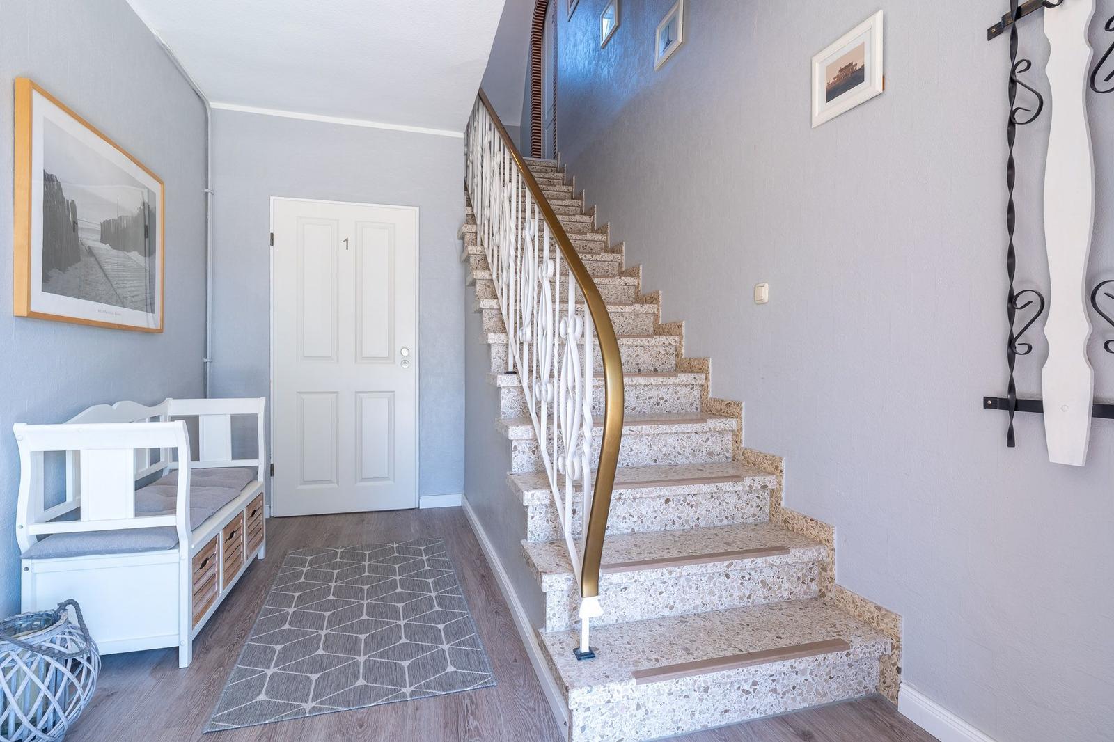 Haus mit Treppe, weiße Tür und Sitzbank mit Kasten