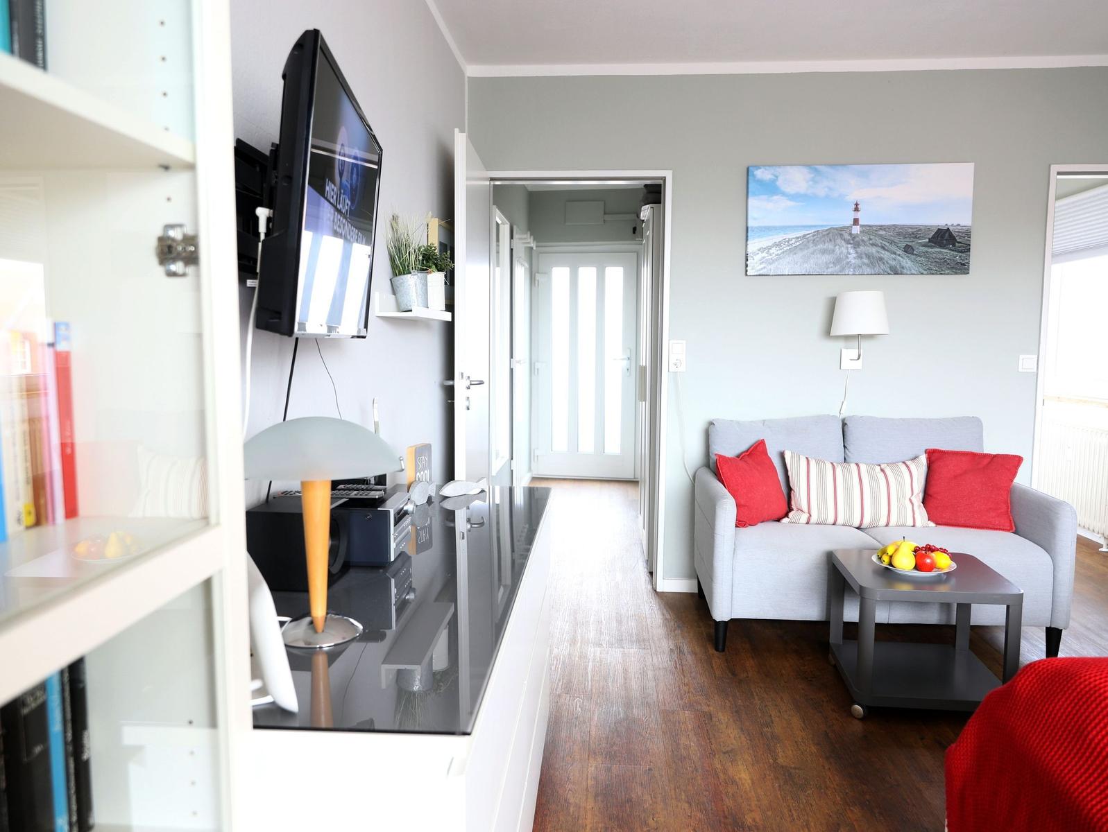 Wohnzimmer mit Sofa, Fernseher und Wandbild