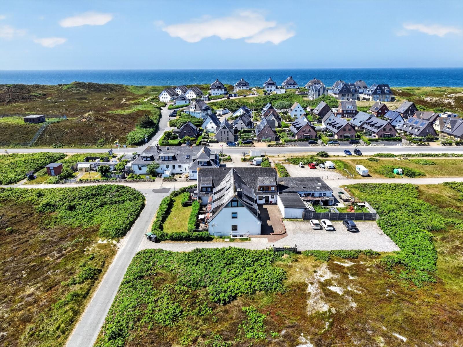 Haus mit Garten und Parkplatz, Blick auf Küstenstraße und Meer.