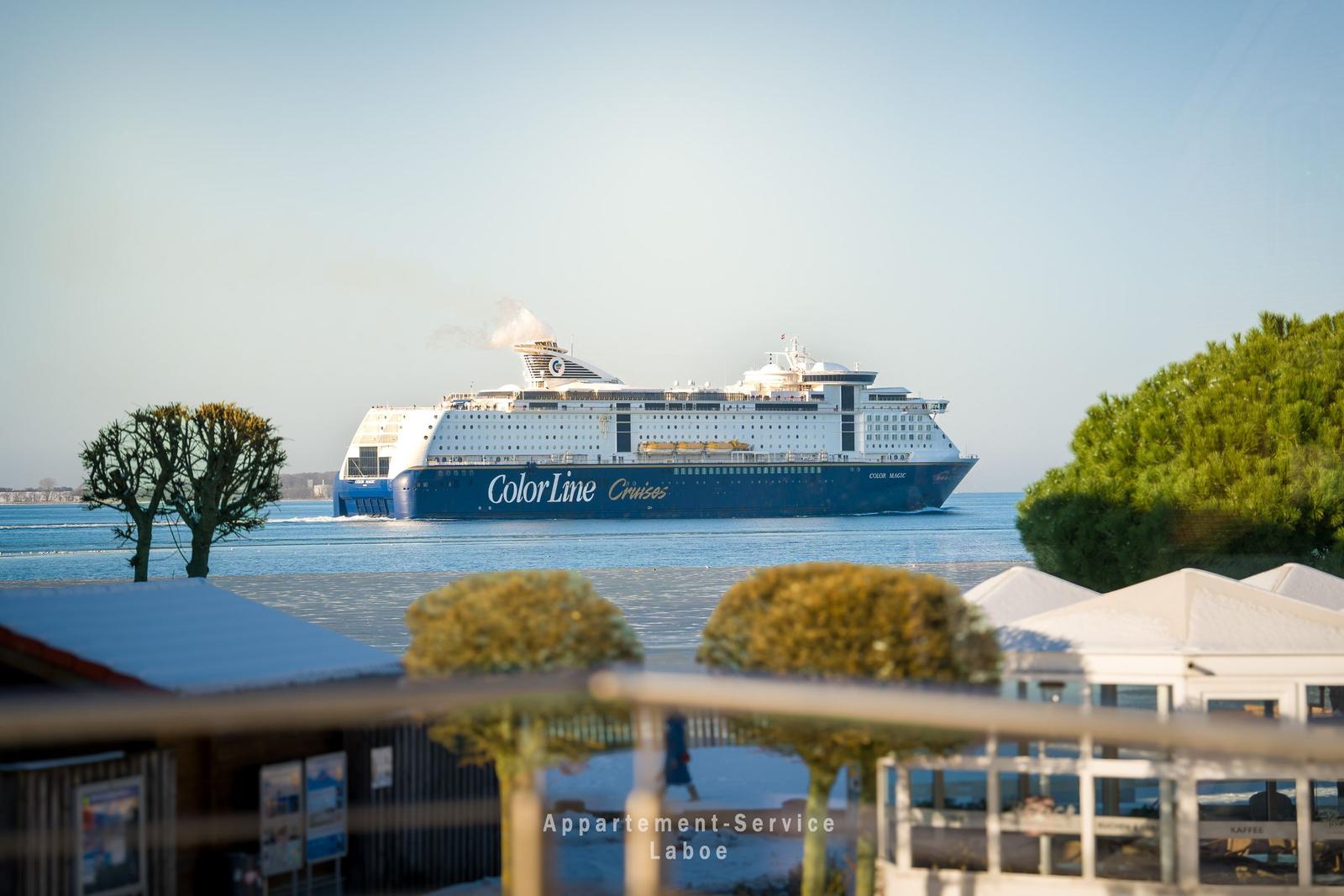 Großes Kreuzfahrtschiff Color Magic fährt durch den Hafen. Blick vom Balkon mit Blick auf Wasser und Bäume.