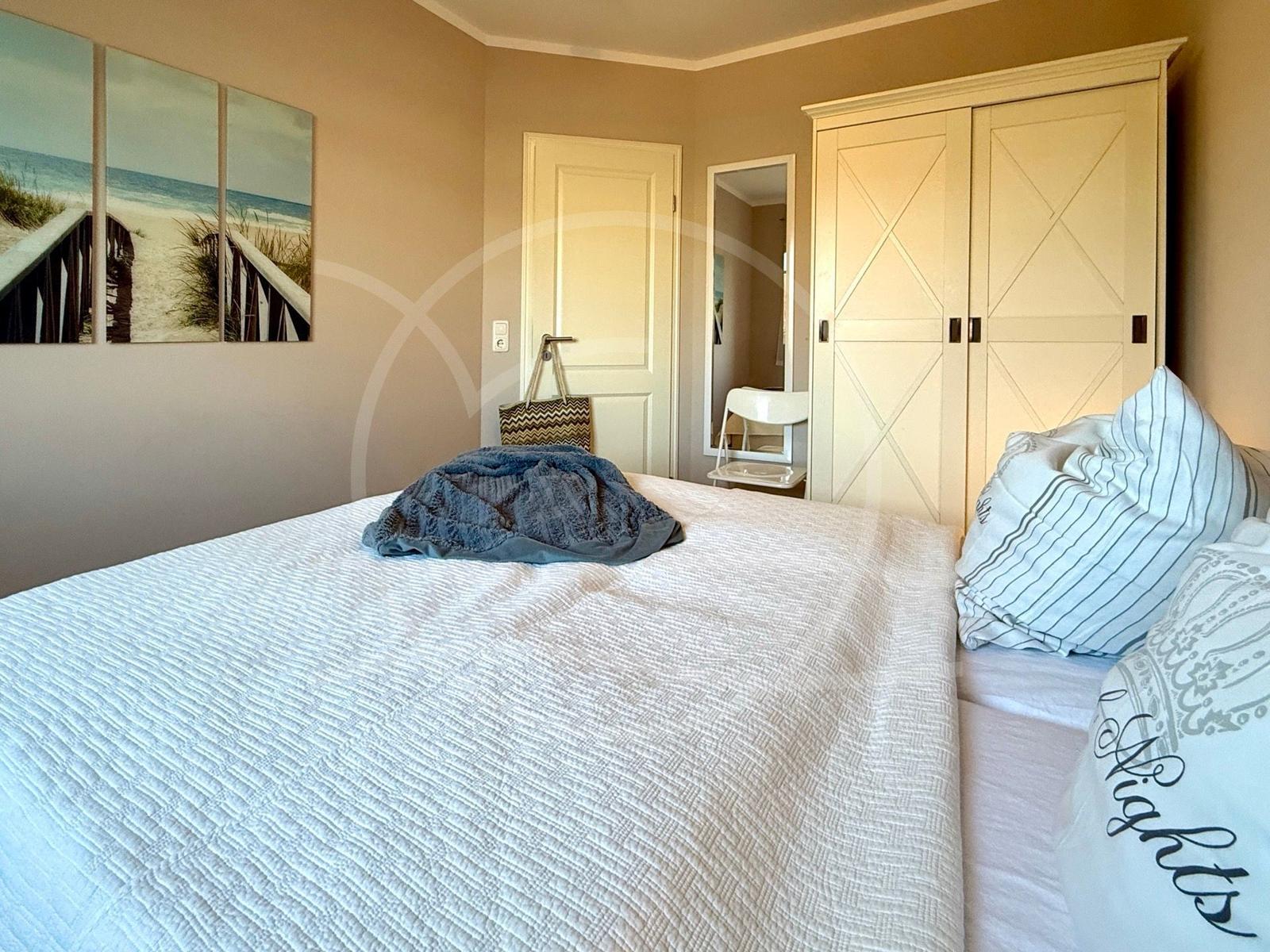 Schlafzimmer mit Doppelbett und Kleiderschrank