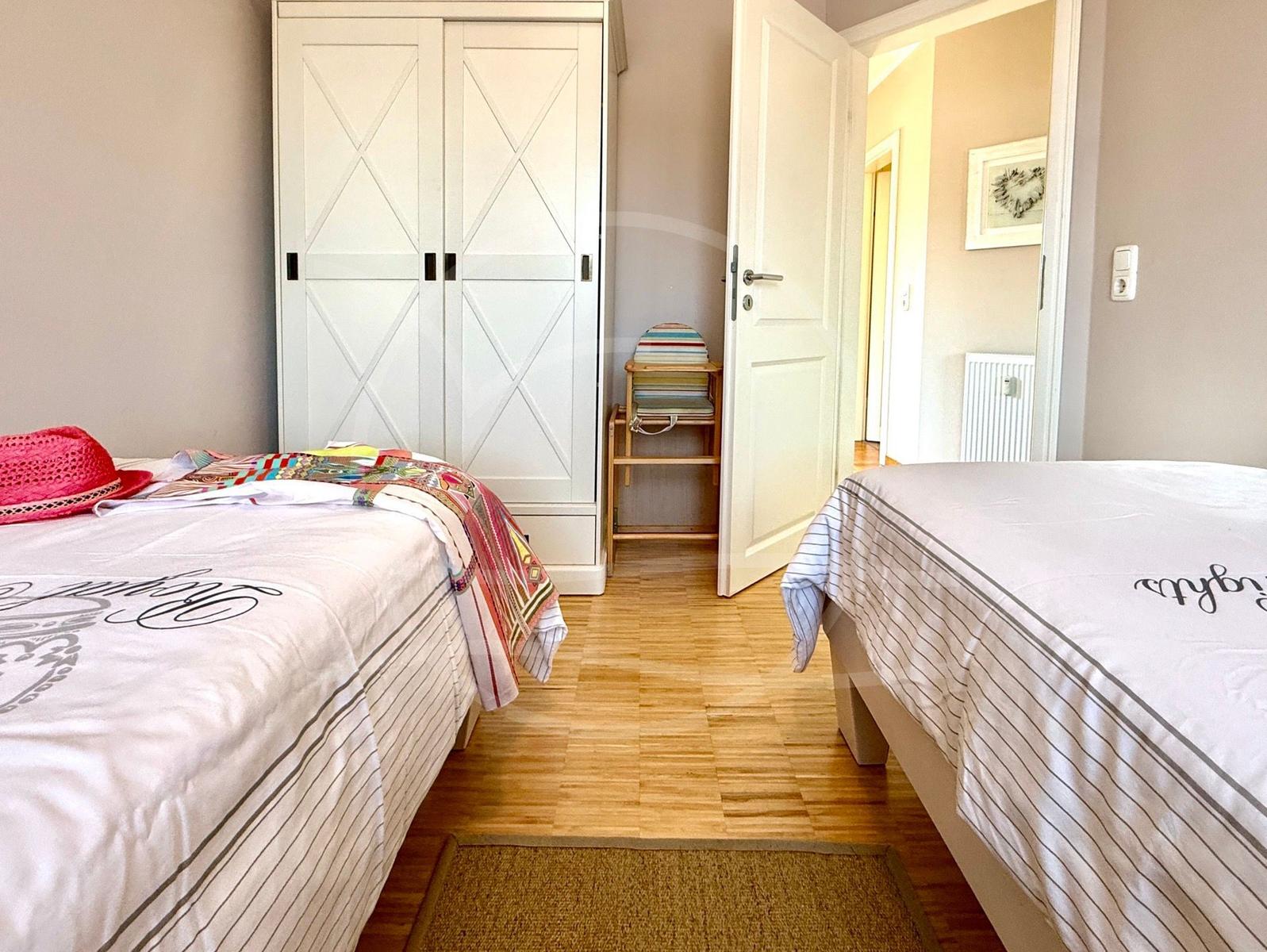 Schlafzimmer mit Einzelbetten und Kleiderschrank