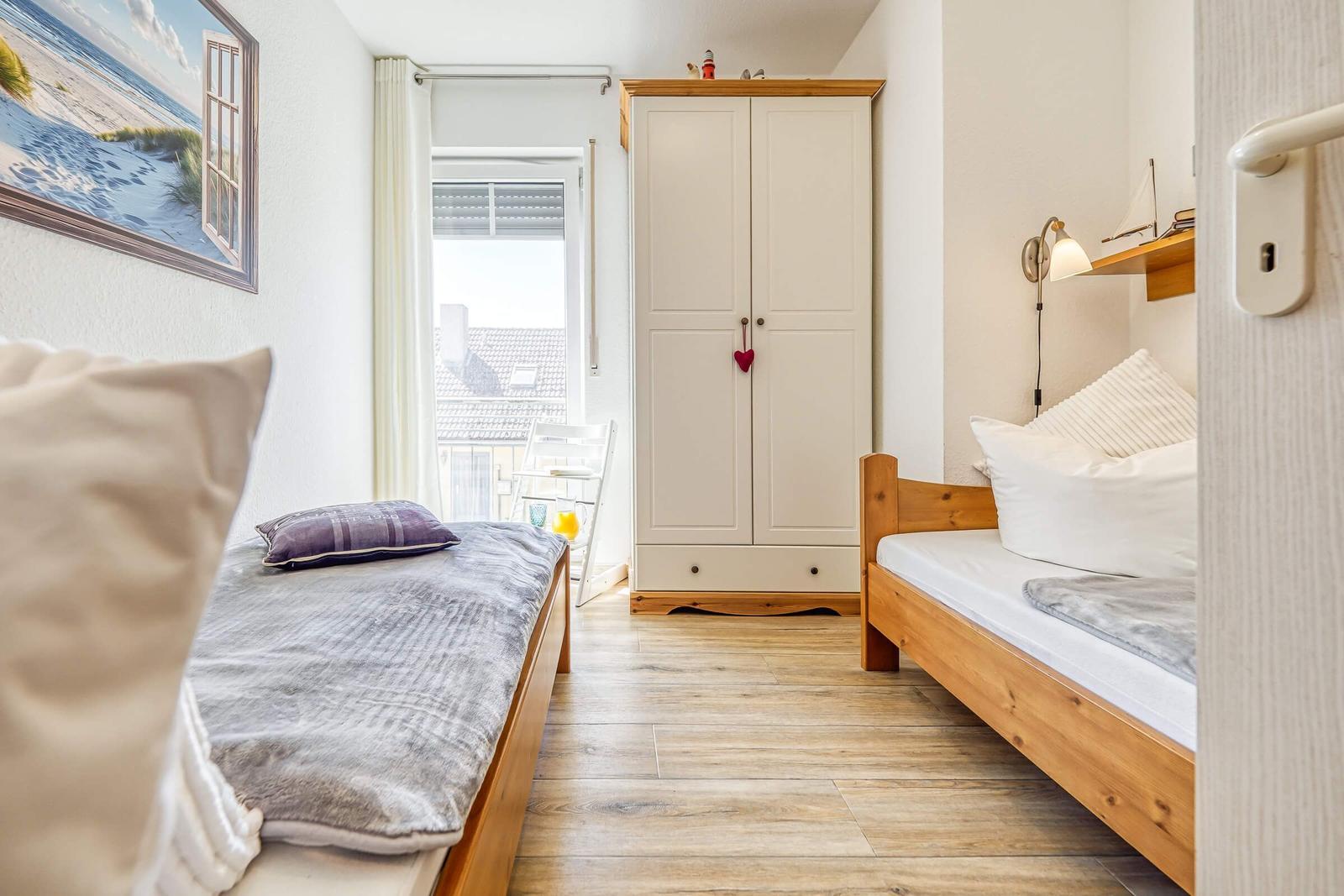 Schlafzimmer mit Einzelbetten und Kleiderschrank