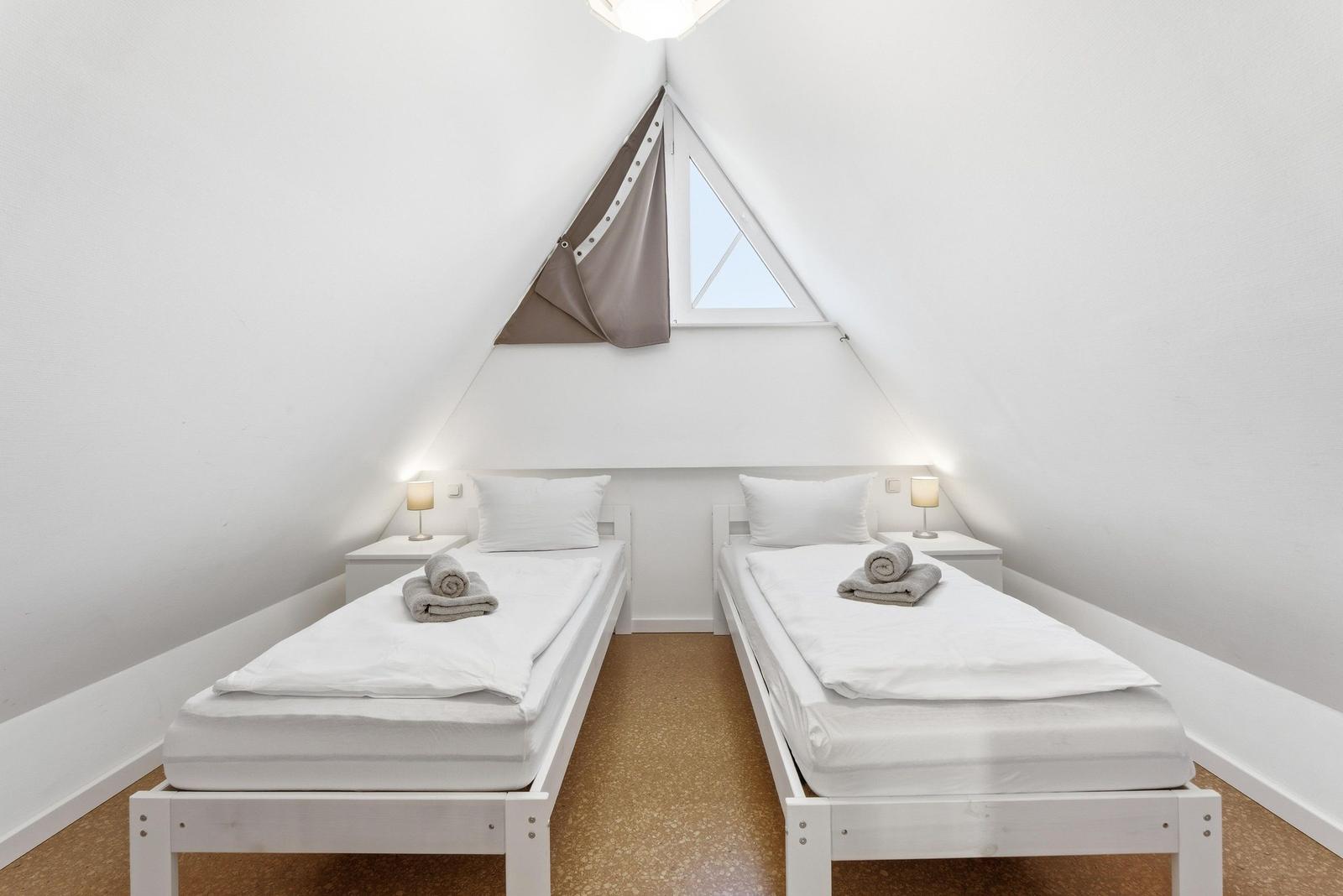 Schlafzimmer mit zwei Einzelbetten und TV