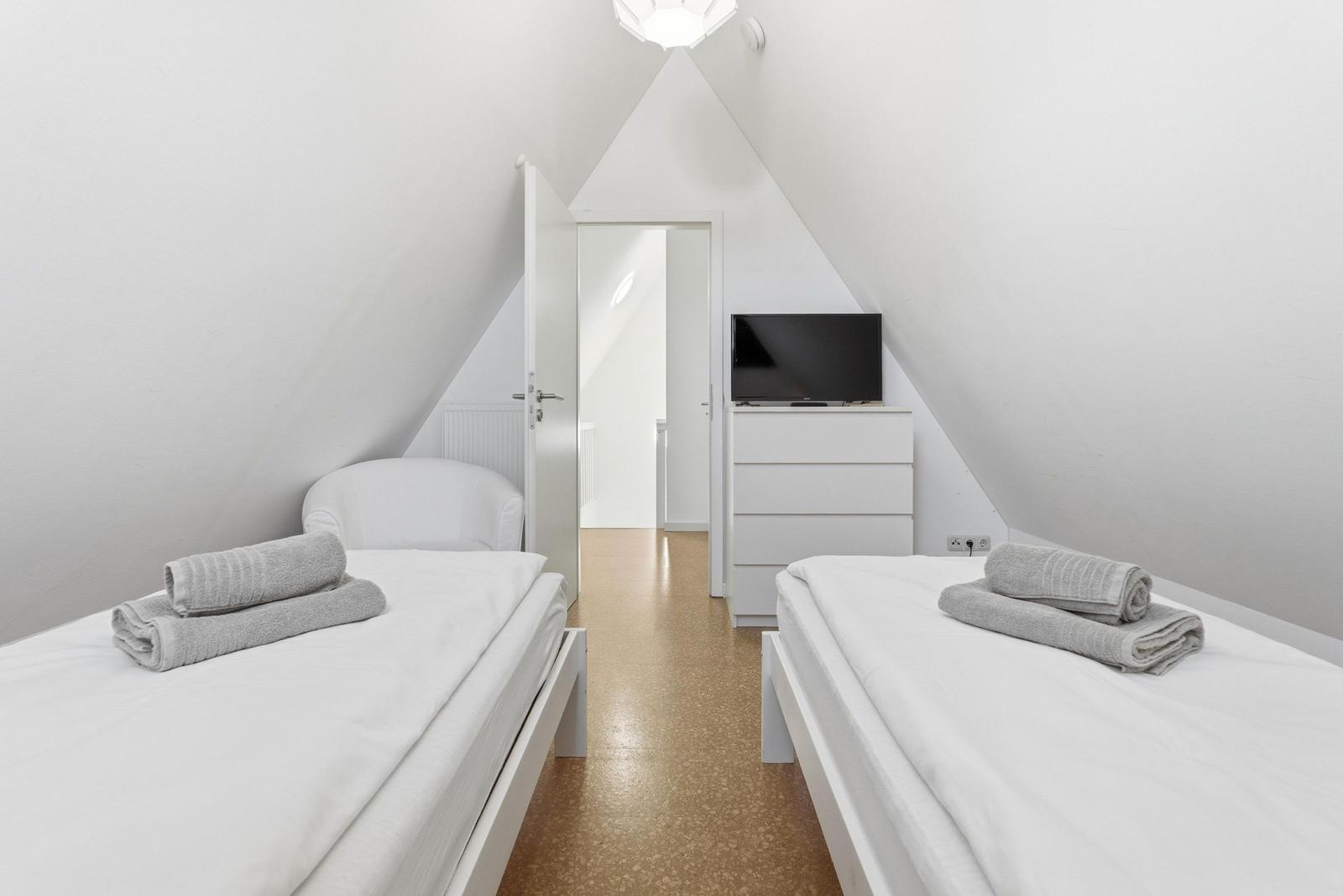 Schlafzimmer mit zwei Einzelbetten und TV