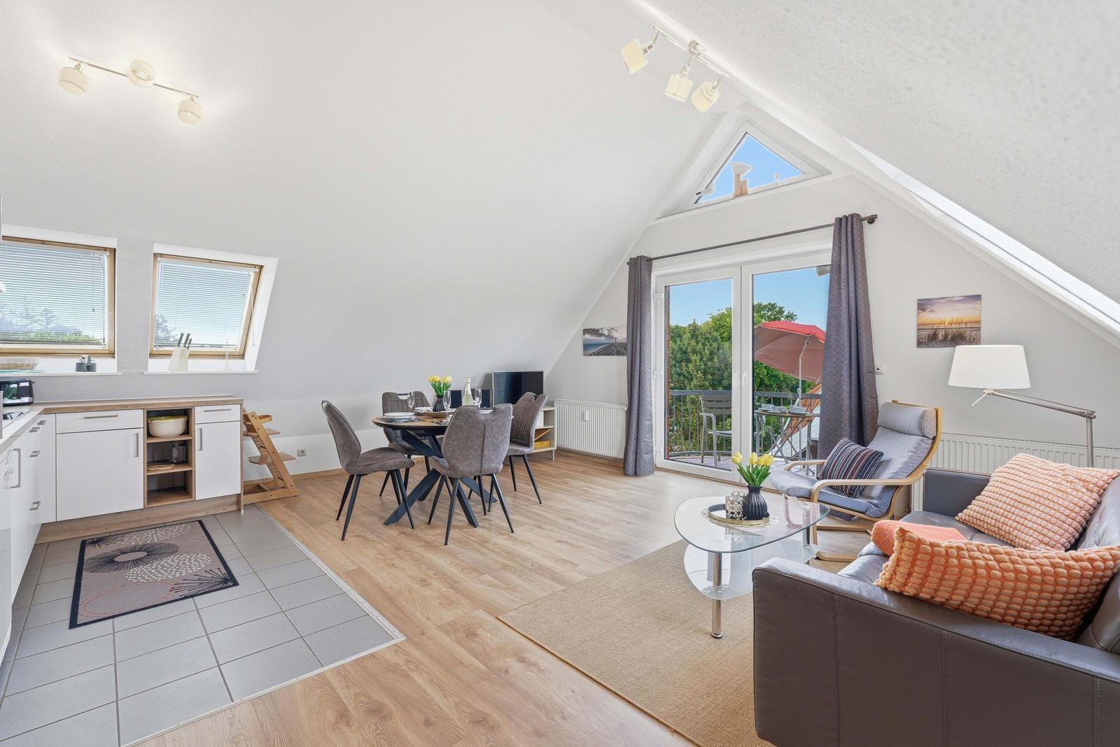 Wohn-Essbereich mit Balkon, Schlafzimmer und Küchenbereich. Holz- und Fliesenboden.