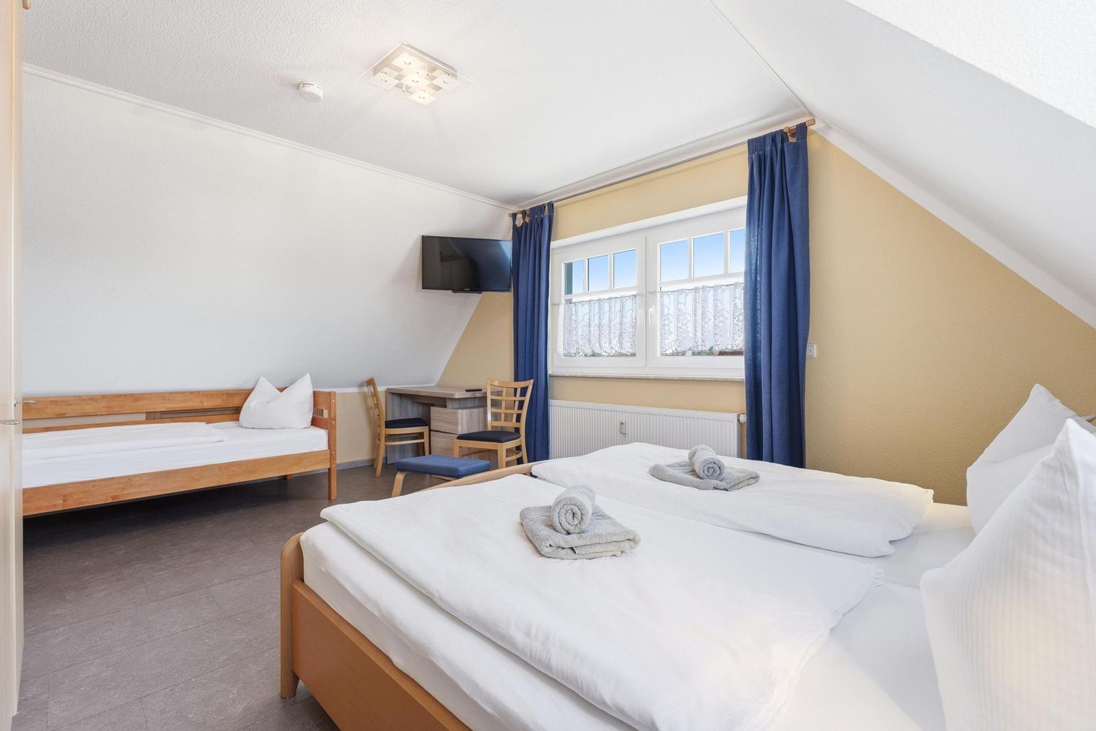 Schlafzimmer mit Doppelbett und einem Einzelbett