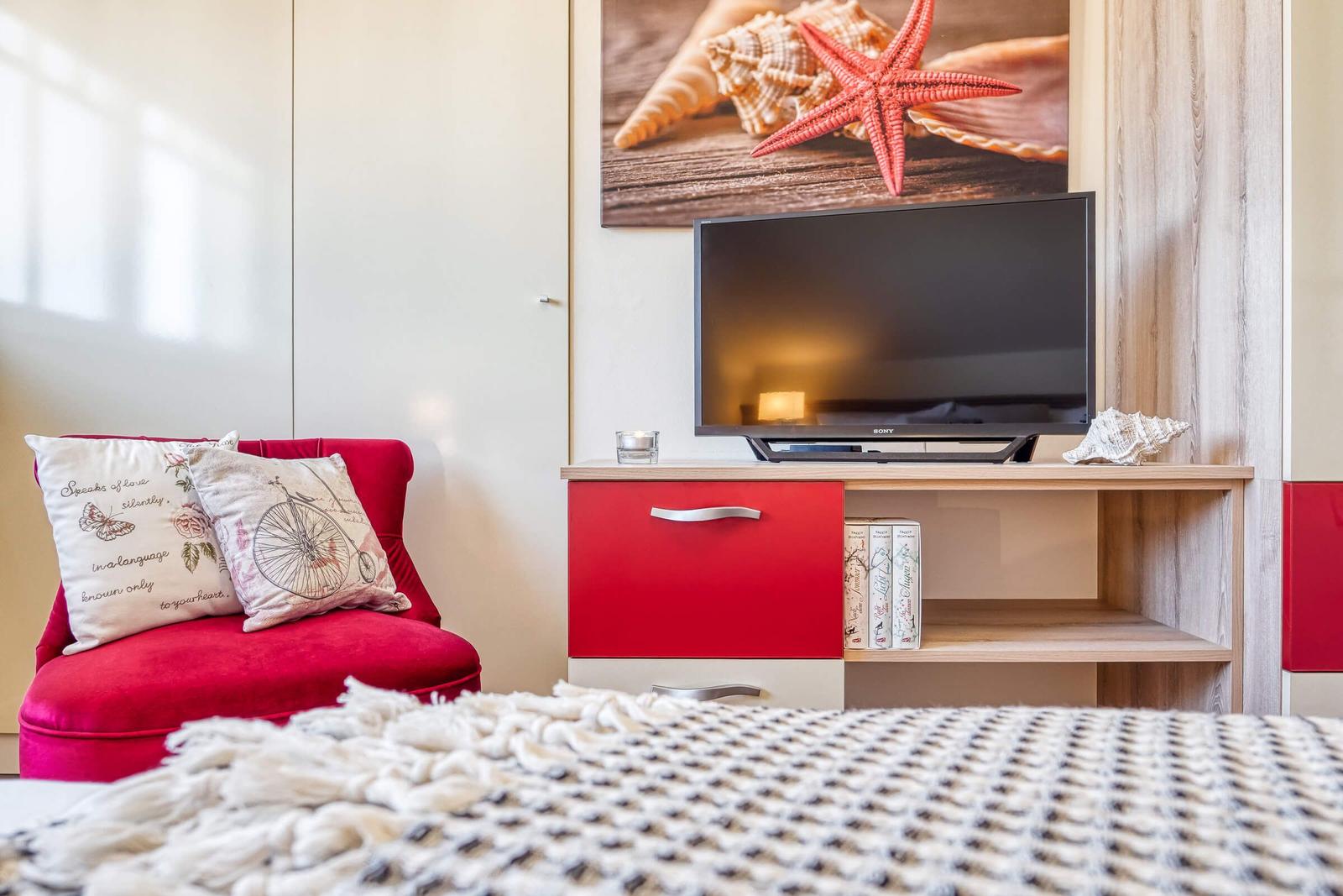 Blick zum TV und Sessel im Schlafzimmer