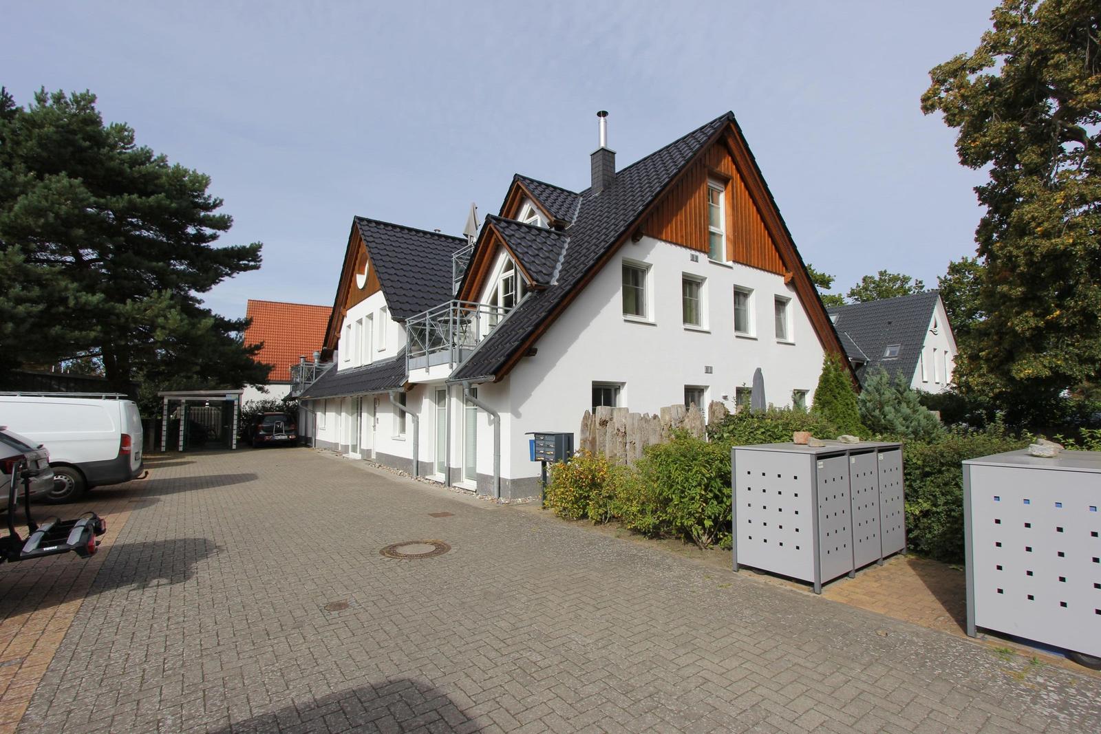 Modernes Haus mit Balkon, gepflastertem Hof und Bäumen