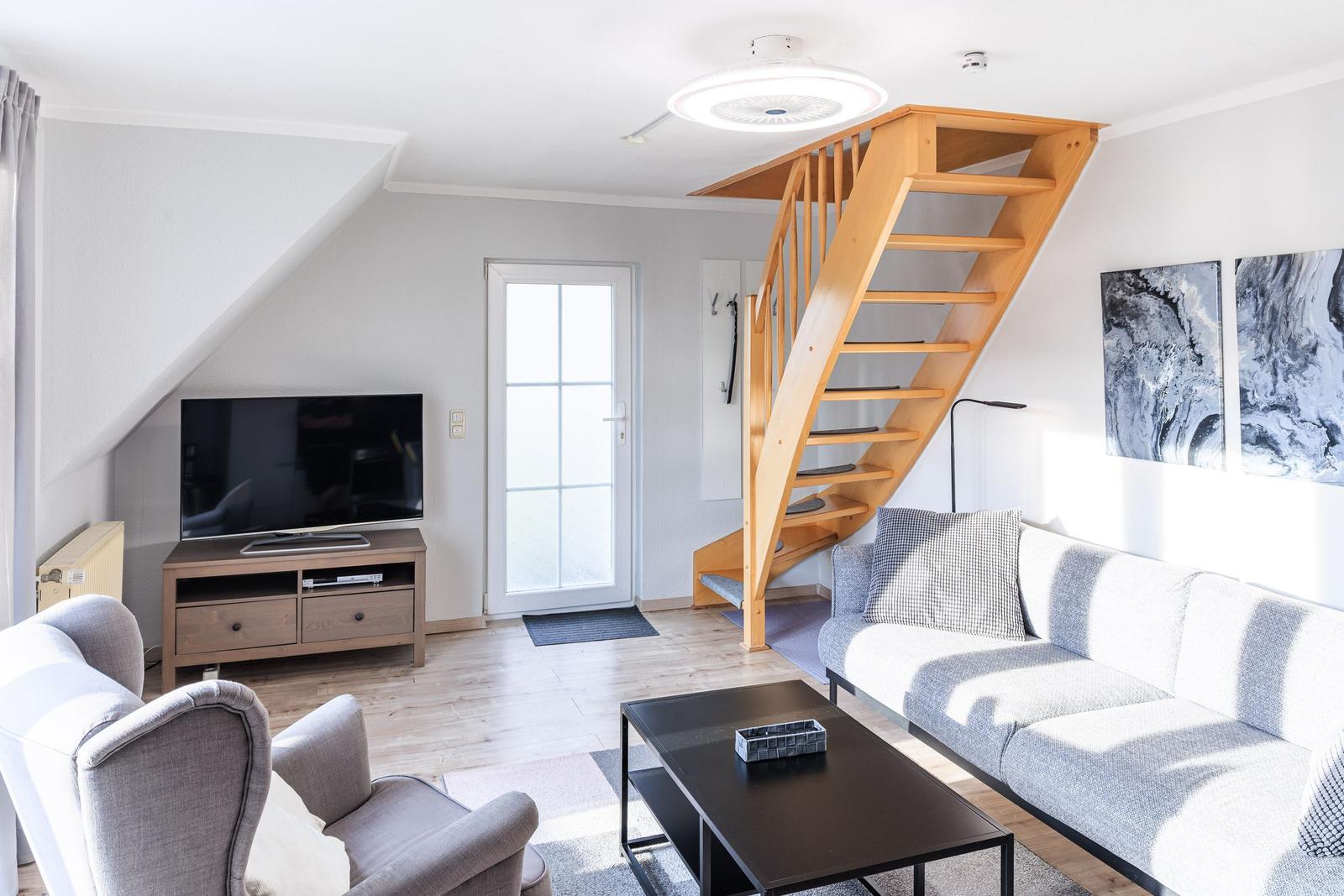 Wohnbereich mit TV und Treppe ins Obergeschoss