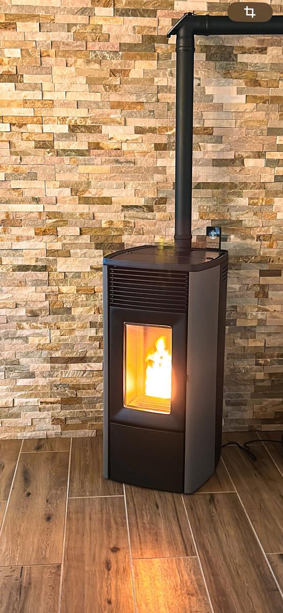 Holzofen mit brennendem Feuer an Steinwand
