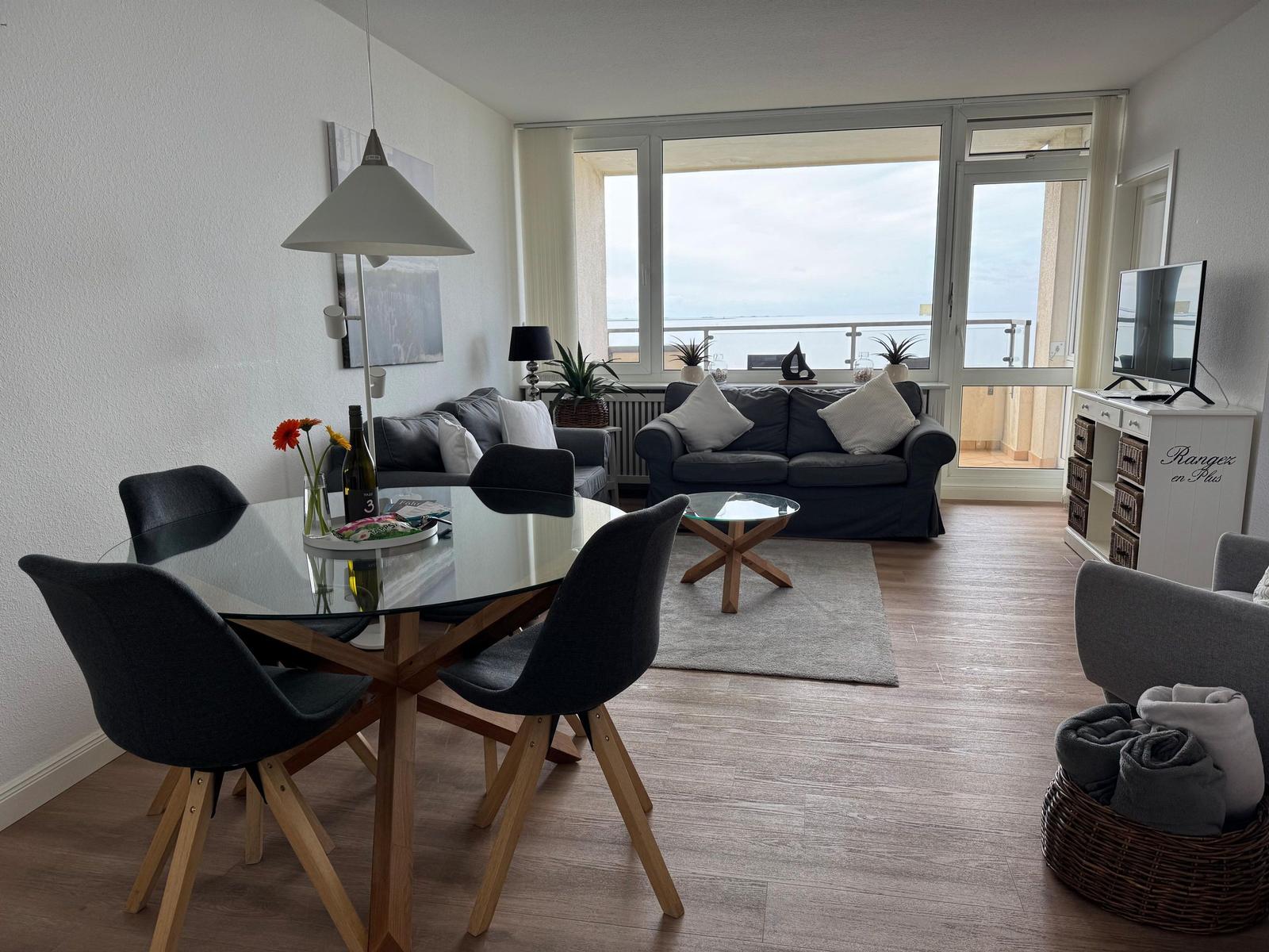 Wohnzimmer mit Essbereich, Sofa und Balkon mit Meerblick.