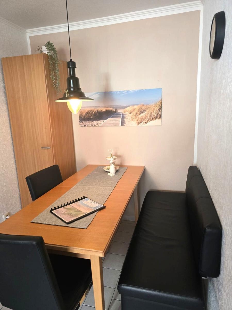 Essbereich mit Tisch, Sitzbank und Wandbild