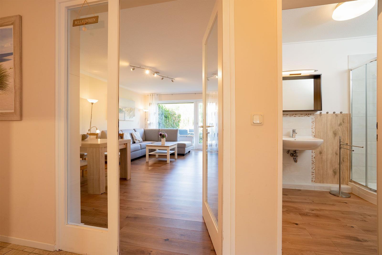 Durchgang zu Wohnzimmer und Bad mit Holzboden und Glaswand