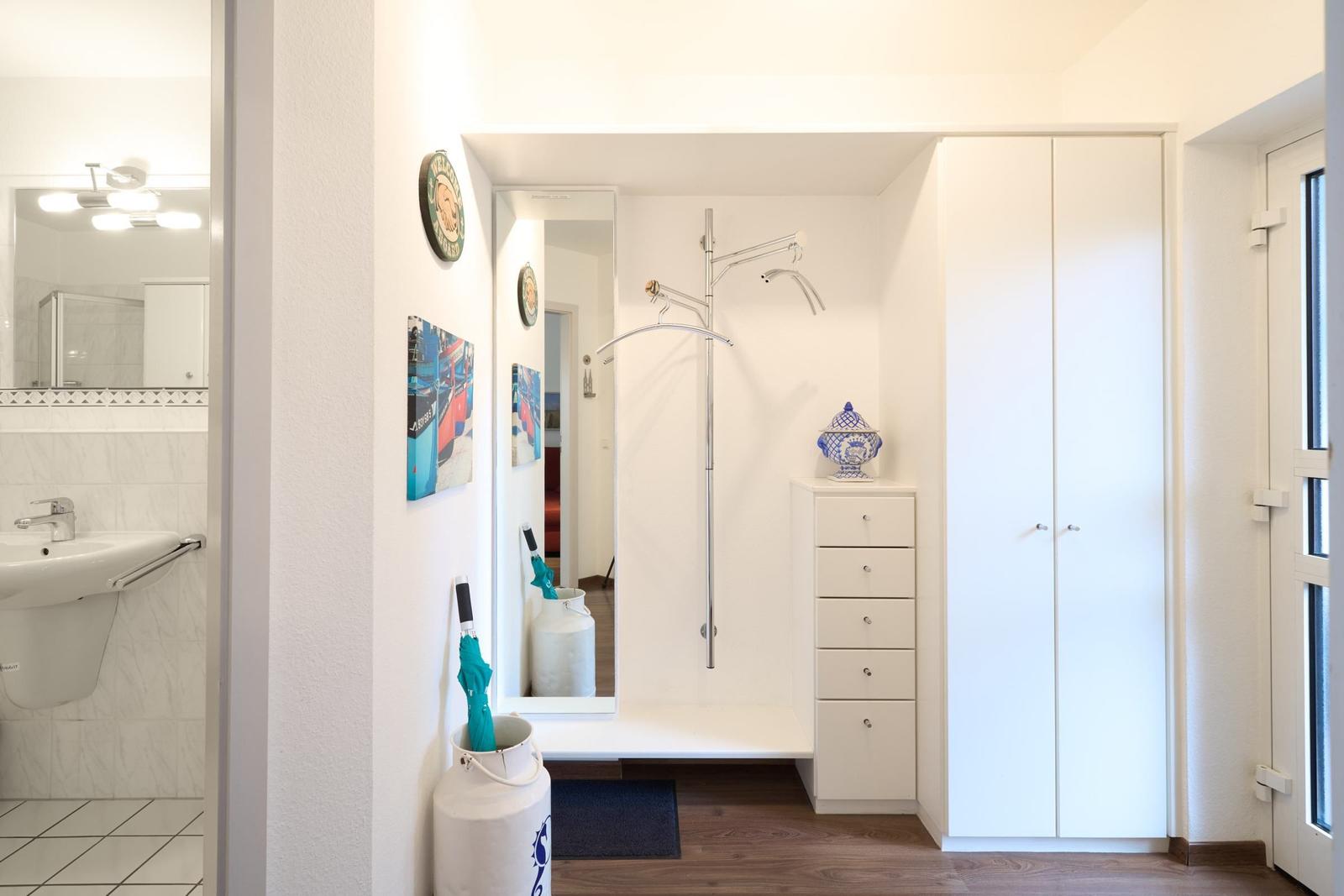 Flur mit Dusche, Schrank und Waschbecken im angrenzenden Bad.