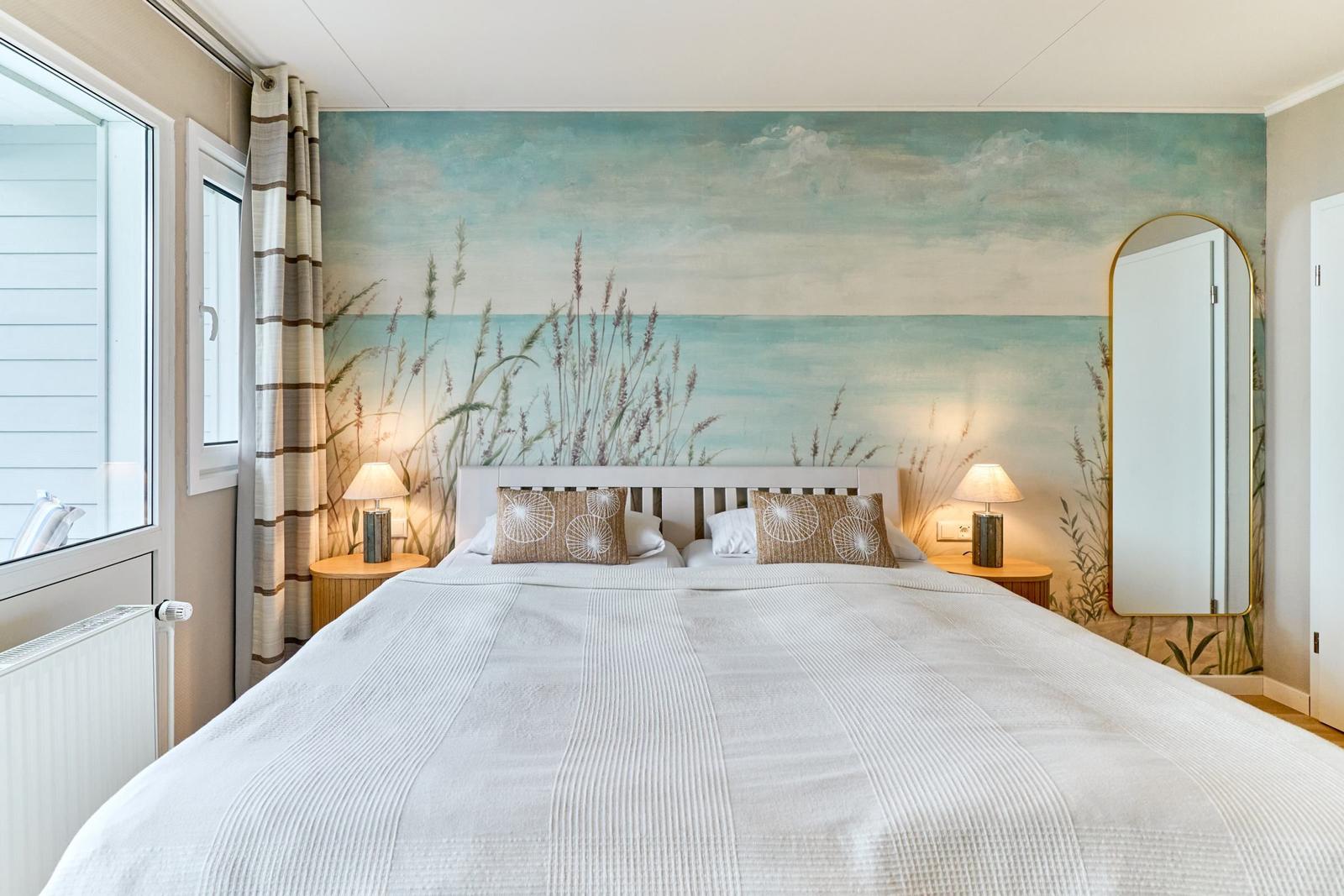 Schlafzimmer mit Bett, Wandbild und Spiegel