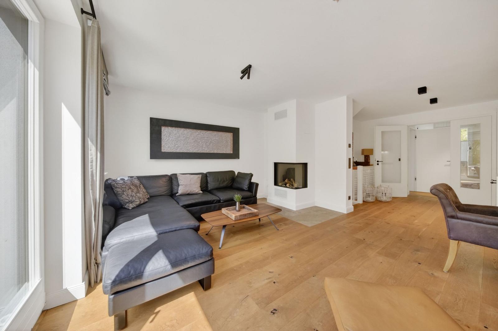 Wohnzimmer mit Ledersofa, Holzboden und Kamin