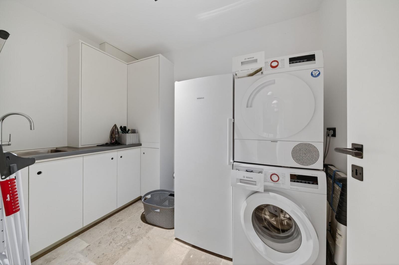 Wohnung mit Waschmaschine, Trockner und Küchenzeile.