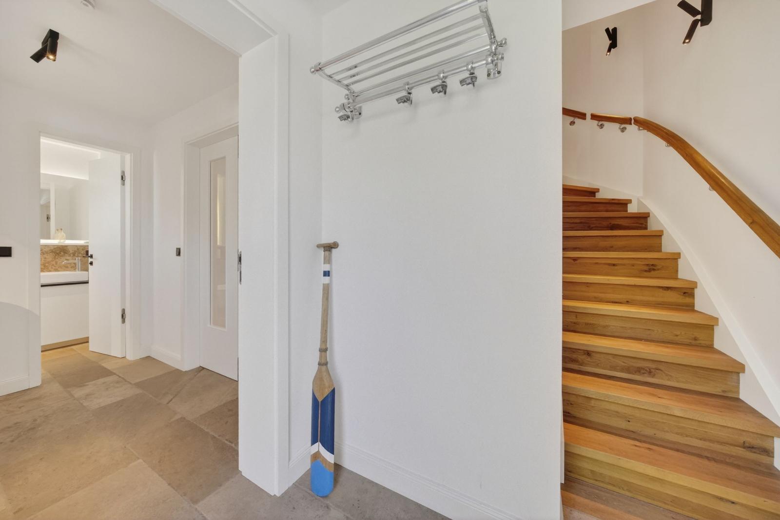 Eingangsbereich mit Holztreppe und Ruderboot an der Wand.