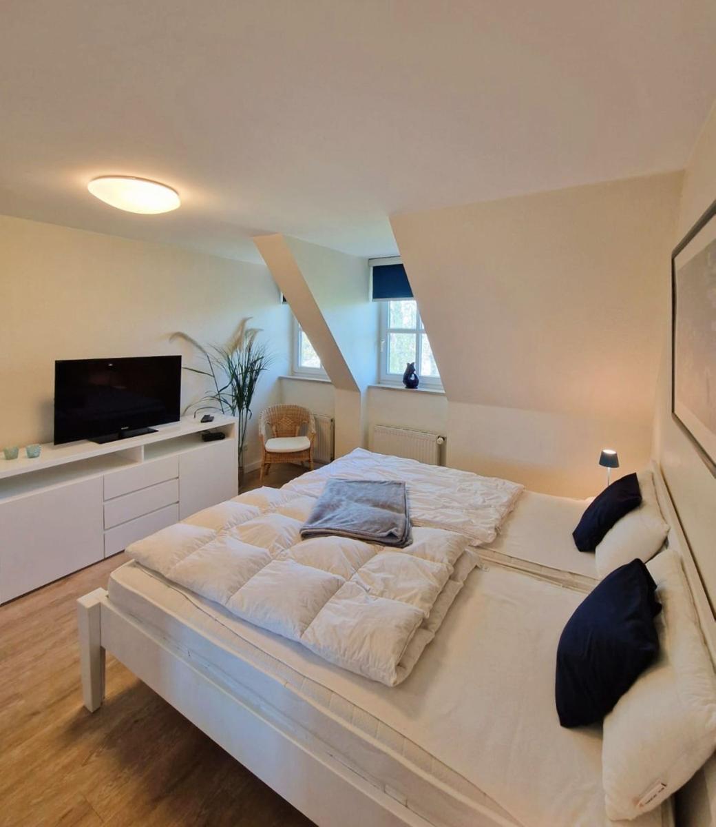 Schlafzimmer mit Doppelbett, Fernseher und Fenster