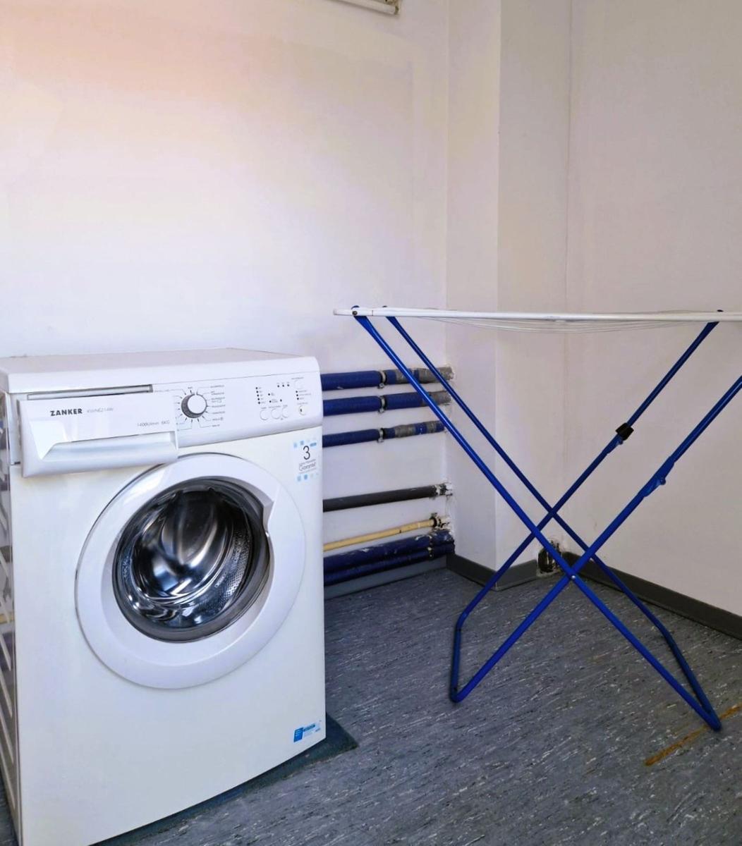 Waschmaschine und Wäscheständer im Raum