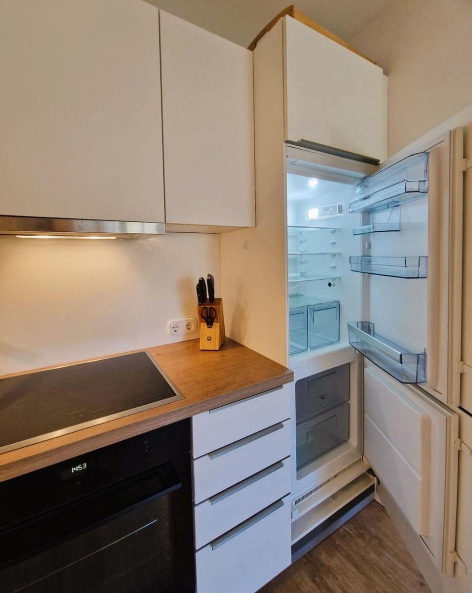 Küche mit Kühlschrank, Herd und Schränken