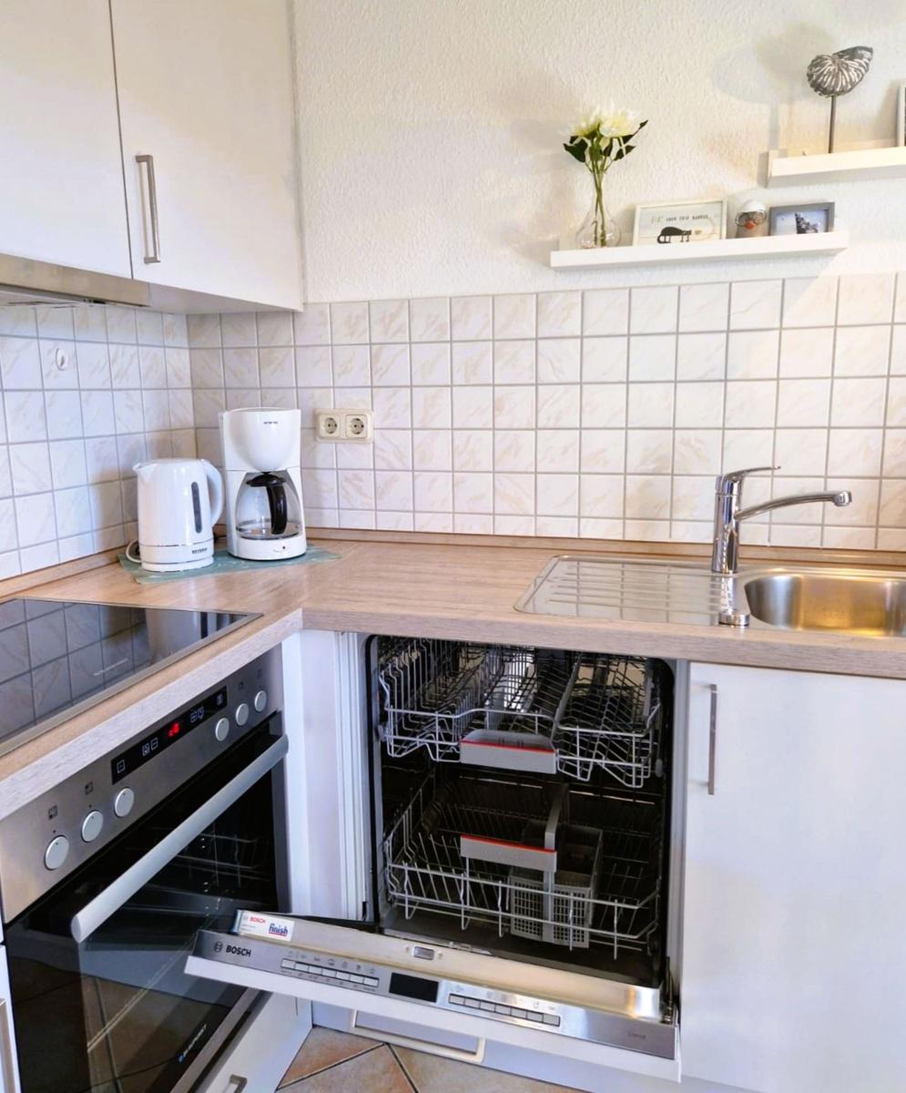 Küche mit Spüle, Geschirrspüler und Kaffeemaschine