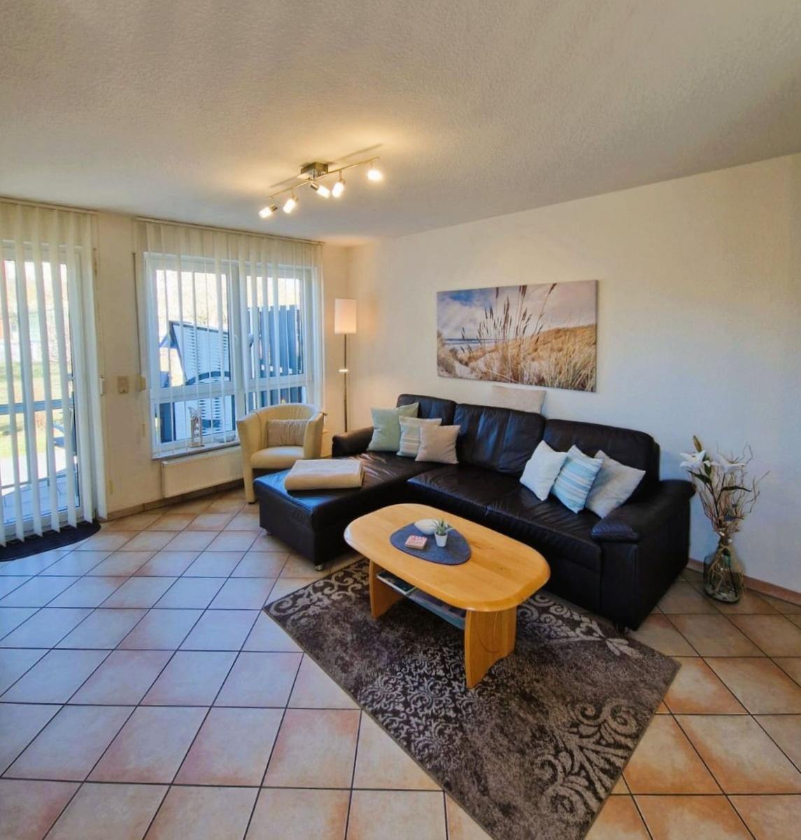 Wohnzimmer mit Sofa, Couchtisch und Fenster zur Terrasse.