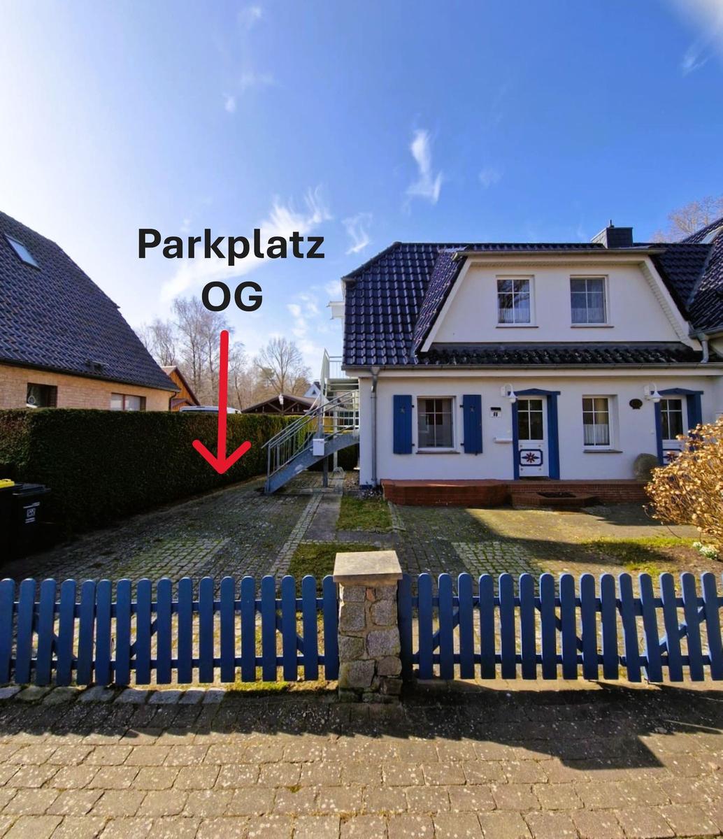 Haus mit blauem Zaun und Parkplatz vor der Tür