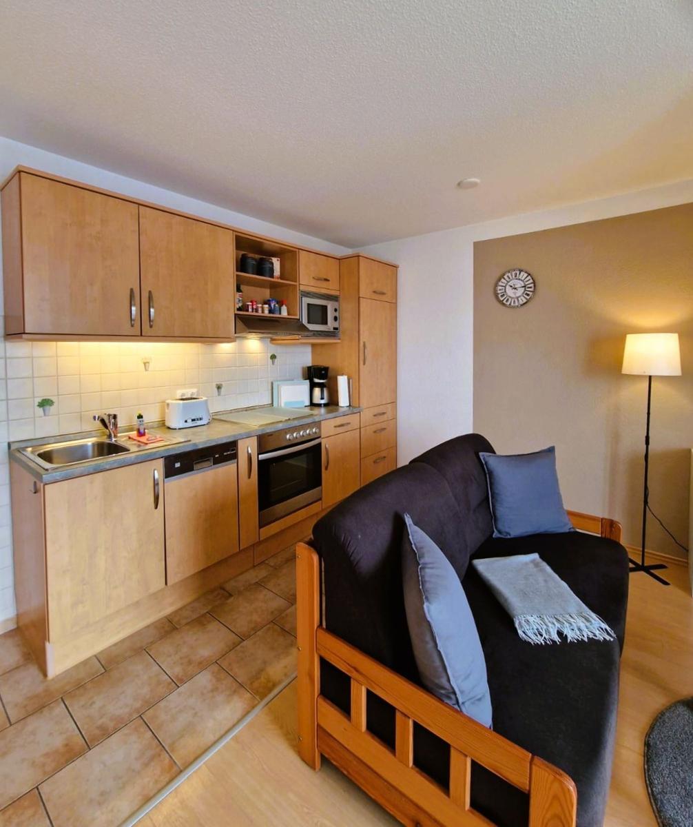 Küche mit Holzmöbeln und Sofa mit Kissen und Decke