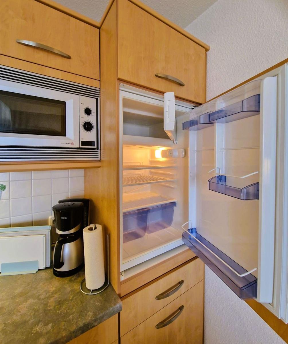 Küche mit Kühlschrank, Mikrowelle und Kaffeemaschine.