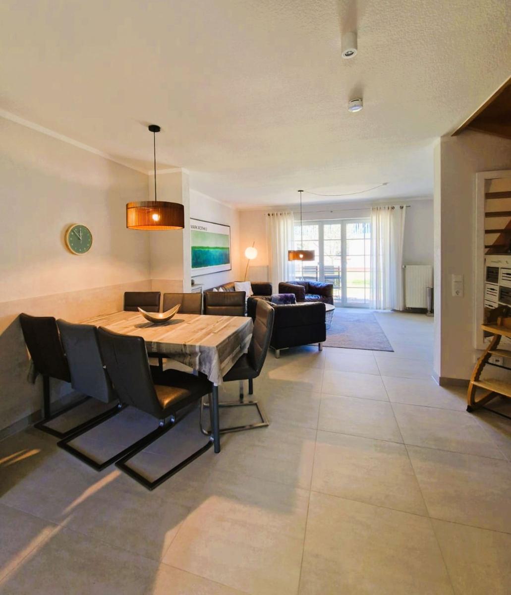 Essbereich mit Tisch und Stühlen, Wohnbereich mit Sofa und Fenster