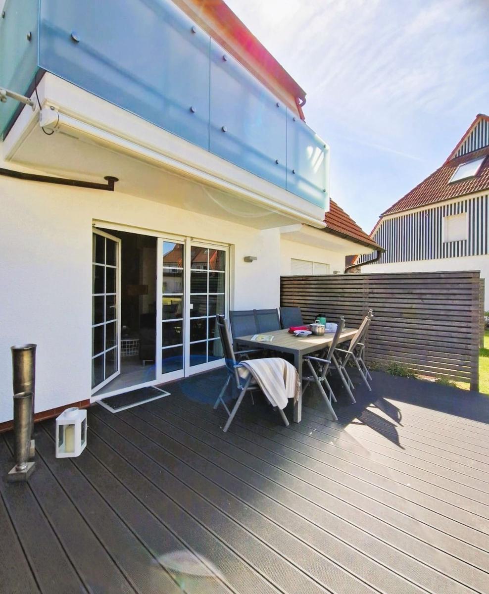 Terrasse mit Tisch, Stühlen und Glastür zur Wohnung